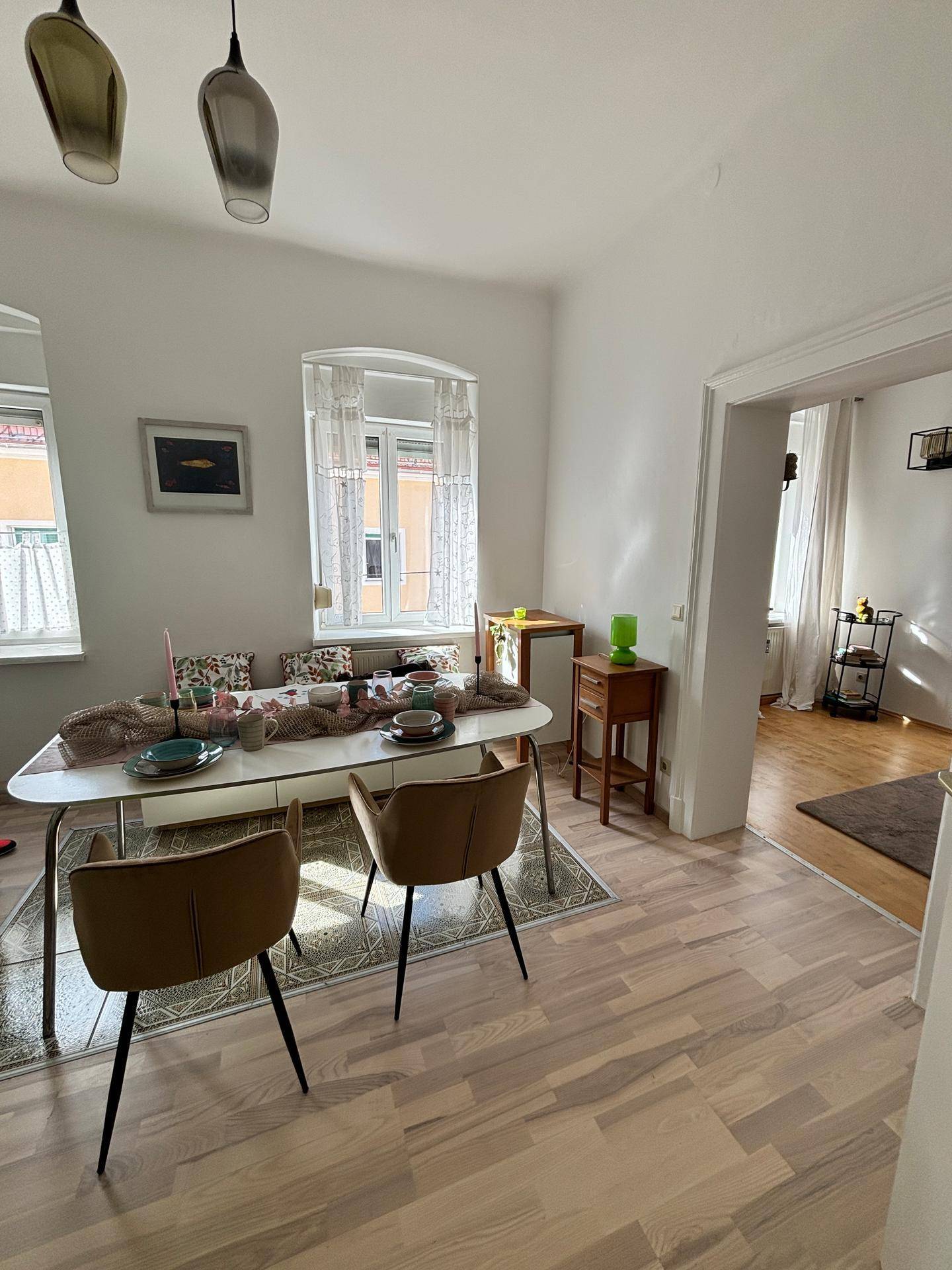 Gemütlicher Essbereich mit Esstisch, modernen Stühlen und Blick durch die Fenster.