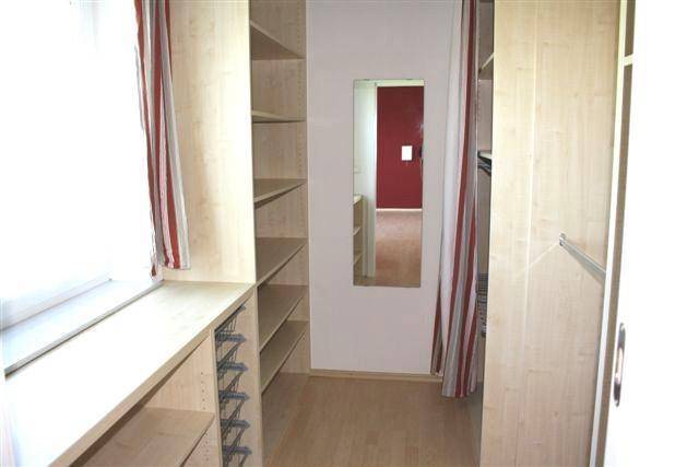 Praktischer begehbarer Kleiderschrank mit Regalsystemen und Spiegel für ausreichend Stauraum.