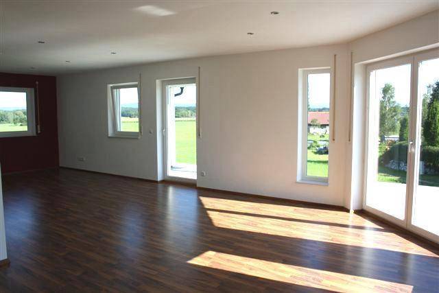 Geräumiger Wohnbereich mit großen Fenstern, viel Tageslicht und Zugang zur Terrasse oder Garten.