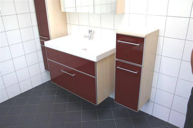 Modernes Badezimmer mit rotem Waschtischunterschrank, weißem Waschbecken und weißen Fliesen.