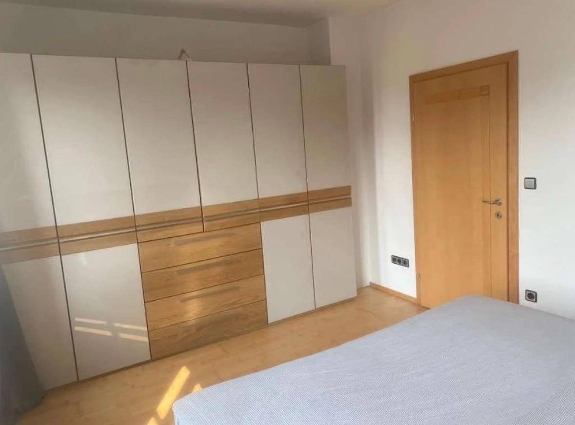 Schlafzimmer mit großem Einbauschrank in Weiß und Holz, bietet viel Stauraum.