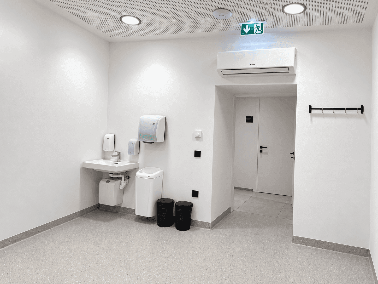 Empfangsbereich mit Waschbecken, Handtuchspendern und Klimaanlage in einem modernen Ambiente.