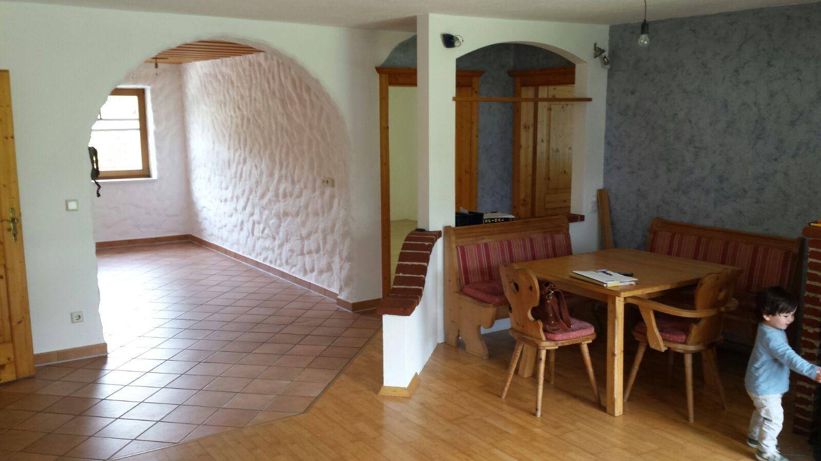 Geräumiger Wohn-Essbereich mit Holzboden und rustikalen Möbeln.