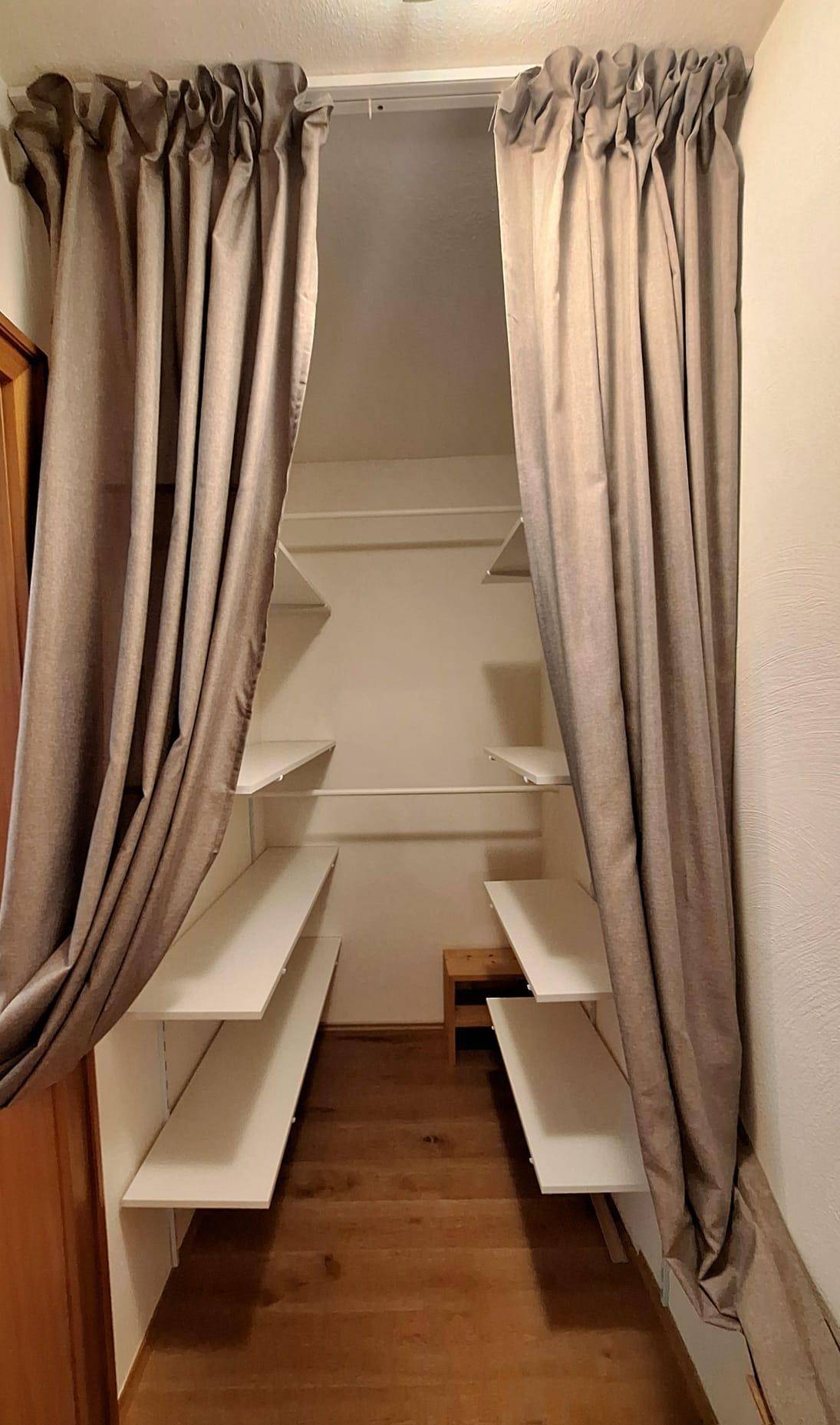 Praktischer Abstellraum oder begehbarer Kleiderschrank mit mehreren Regalböden.