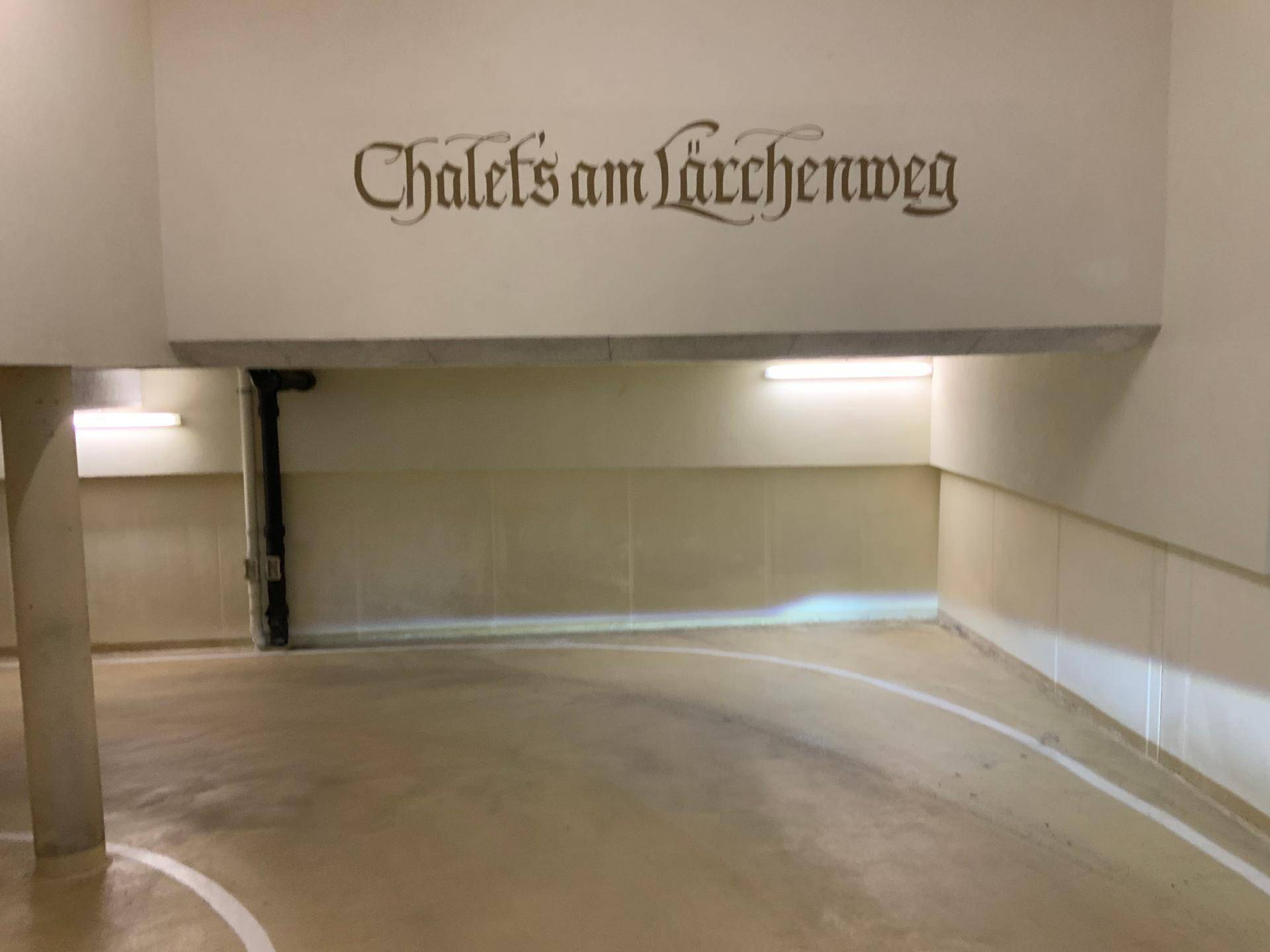 Geräumige Tiefgarage mit heller Beleuchtung und Beschriftung an der Wand.