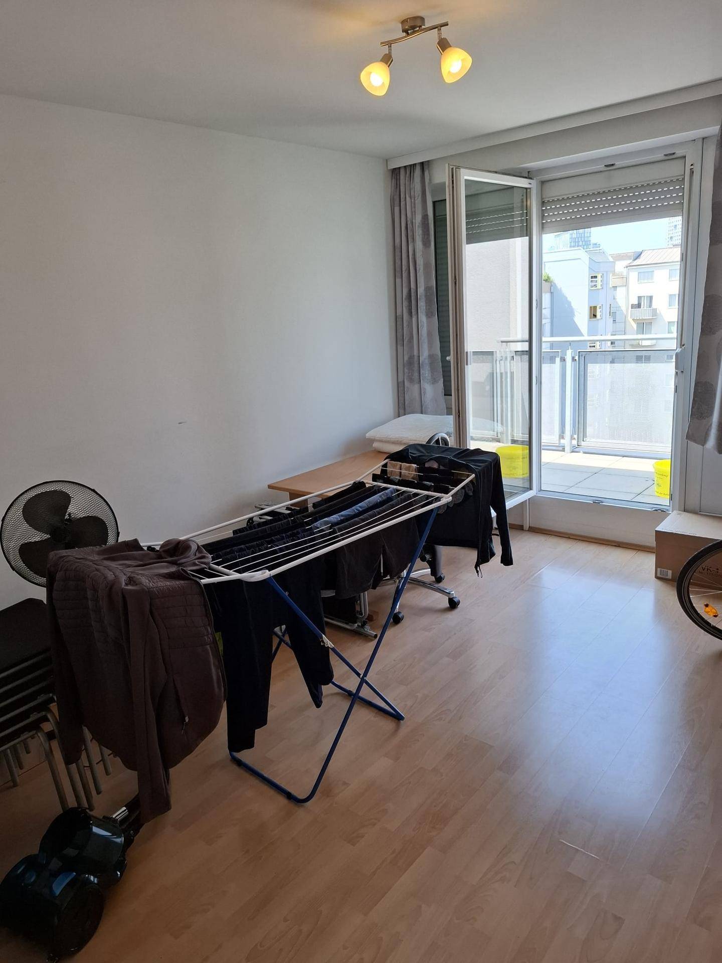 Helles Schlafzimmer mit Parkettboden und Zugang zum Balkon.