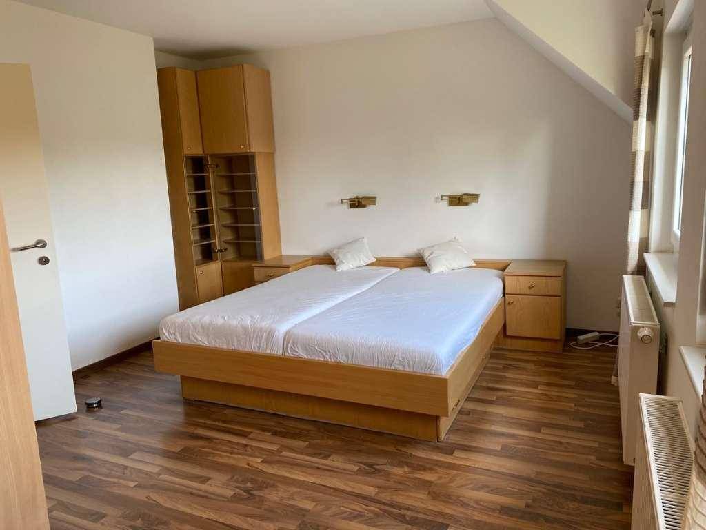 Schlafzimmer mit Doppelbett, Laminatboden und praktischen Einbauschränken.