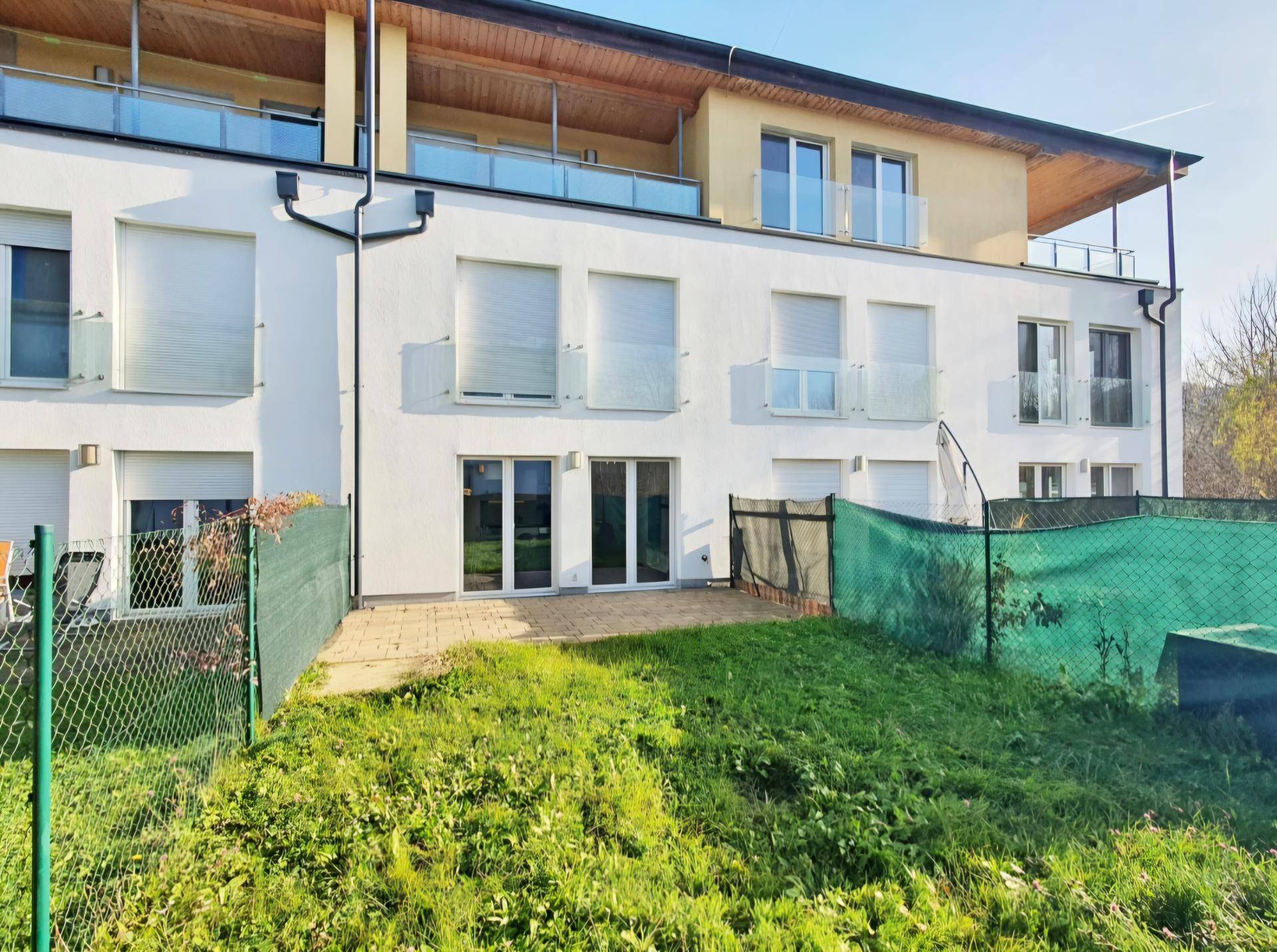 Rückansicht der Reihenhäuser mit privaten Terrassen, Gärten und Balkonen.