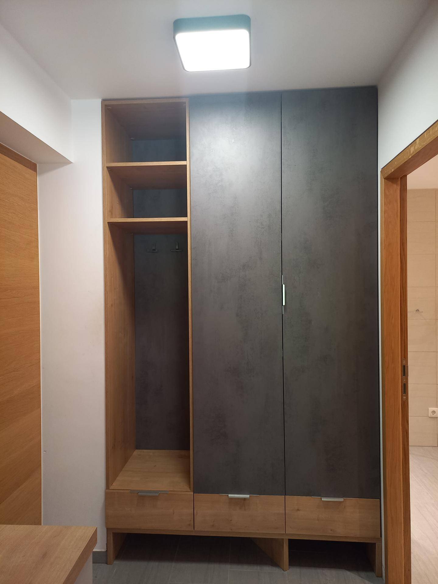 Moderner Einbauschrank im Flur mit offenen Fächern und Holzdetails für Stauraum.