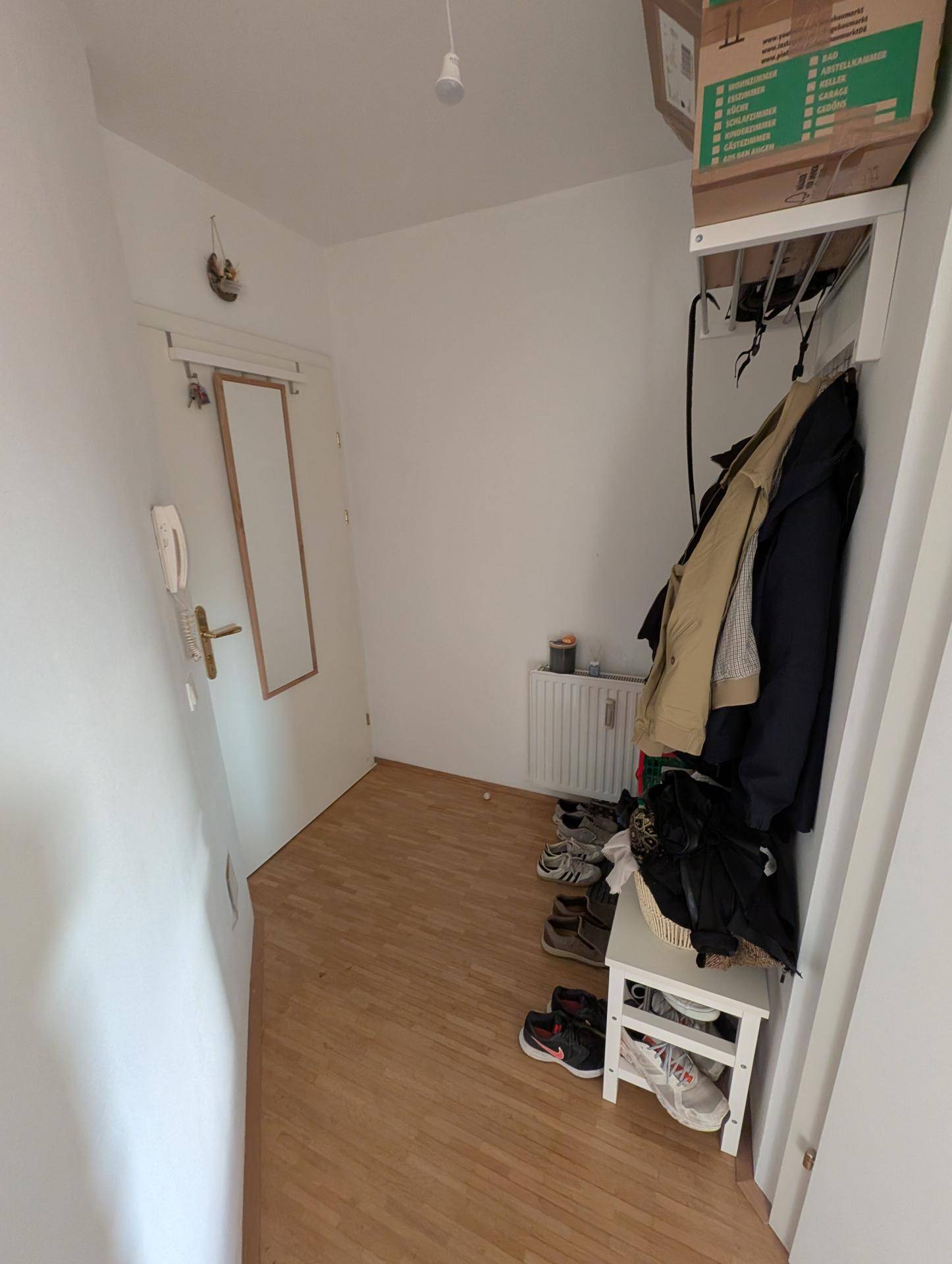 Eingangsbereich mit Garderobe, Schuhregal und Spiegel, hell und funktional gestaltet.