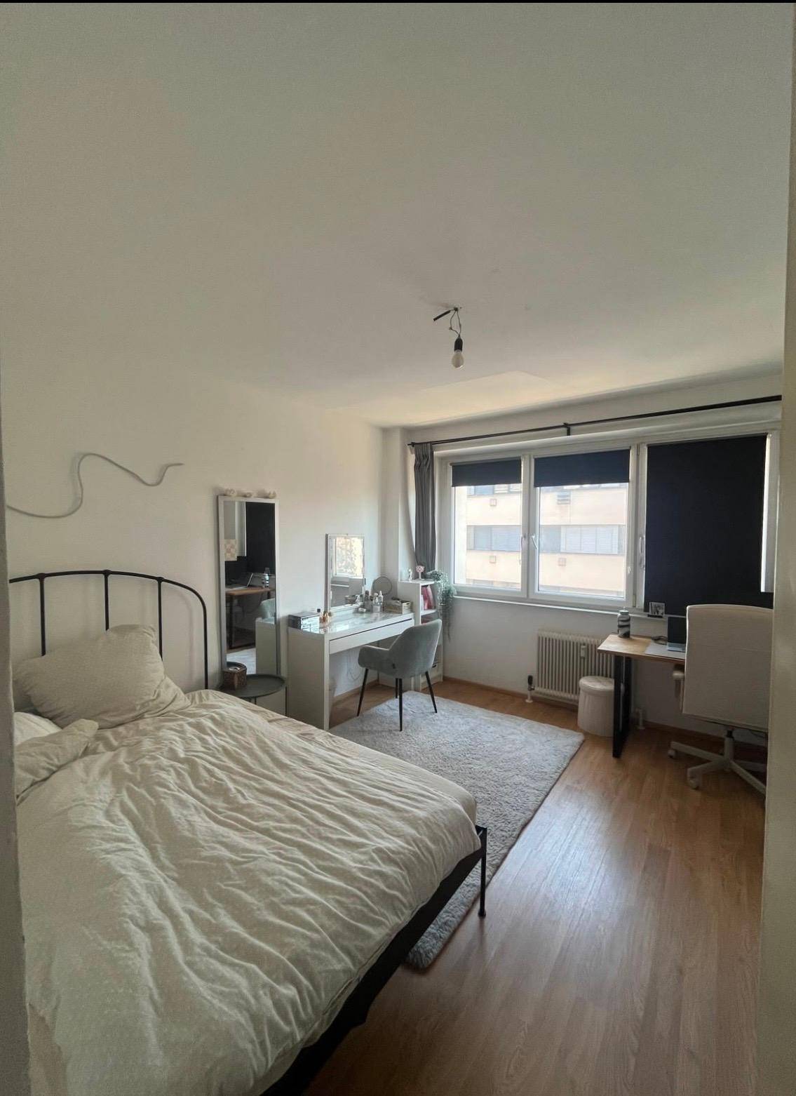 Schlafzimmer mit Schreibtisch, Fenster und Blick auf die Umgebung.