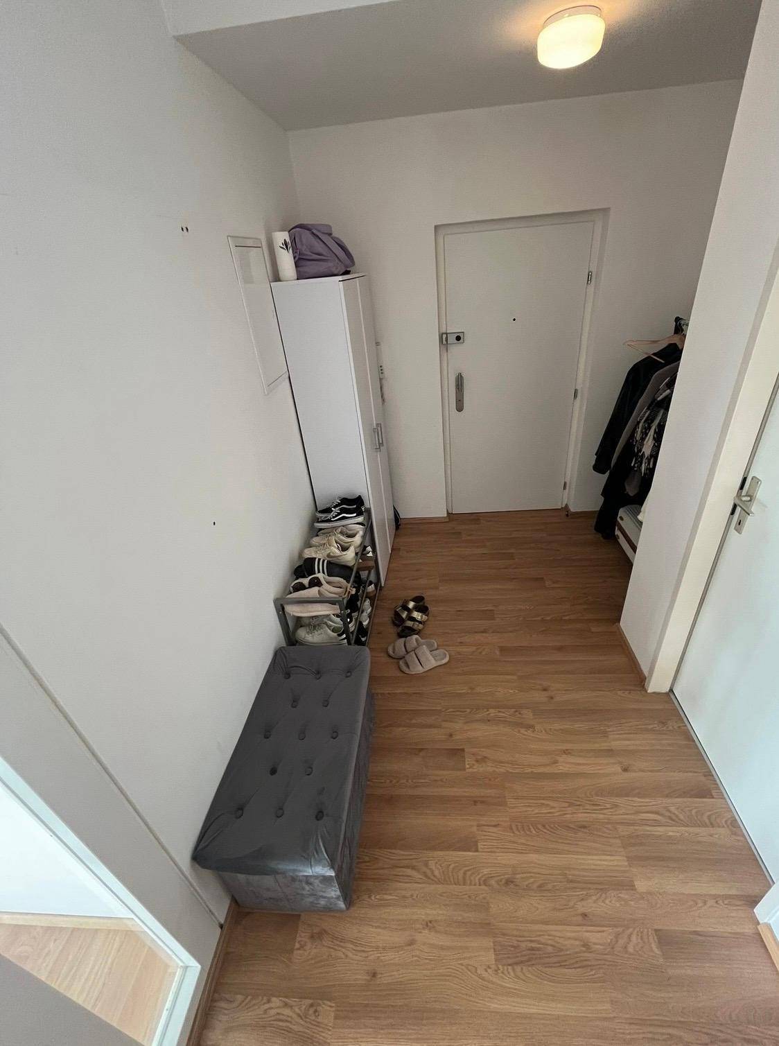 Eingangsbereich mit Holzfußboden, Schuhregal und praktischer Sitzbank.