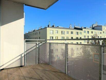 Balkon mit Metallgeländer und Blick auf die umliegenden Wohngebäude der Stadt.