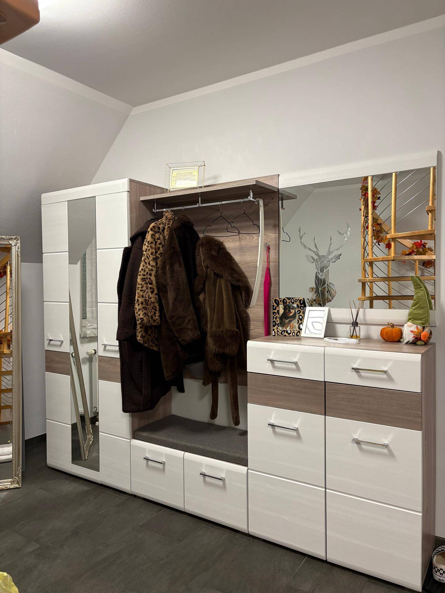 Moderner Garderobenschrank mit Spiegel, Kleiderstange und Schubladen im Eingangsbereich.