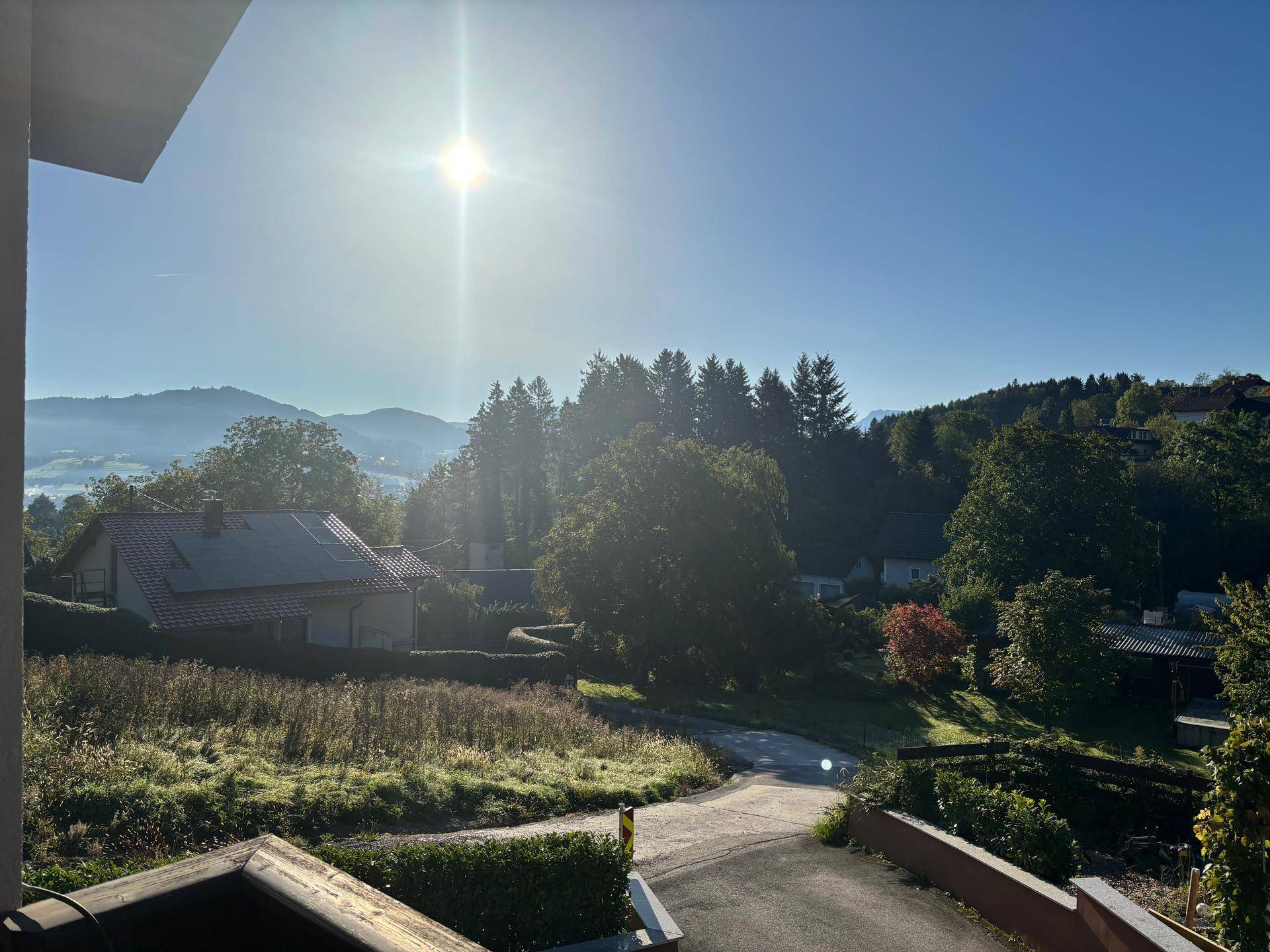 Panoramablick auf die umliegende Berglandschaft und das Tal bei Sonnenaufgang.