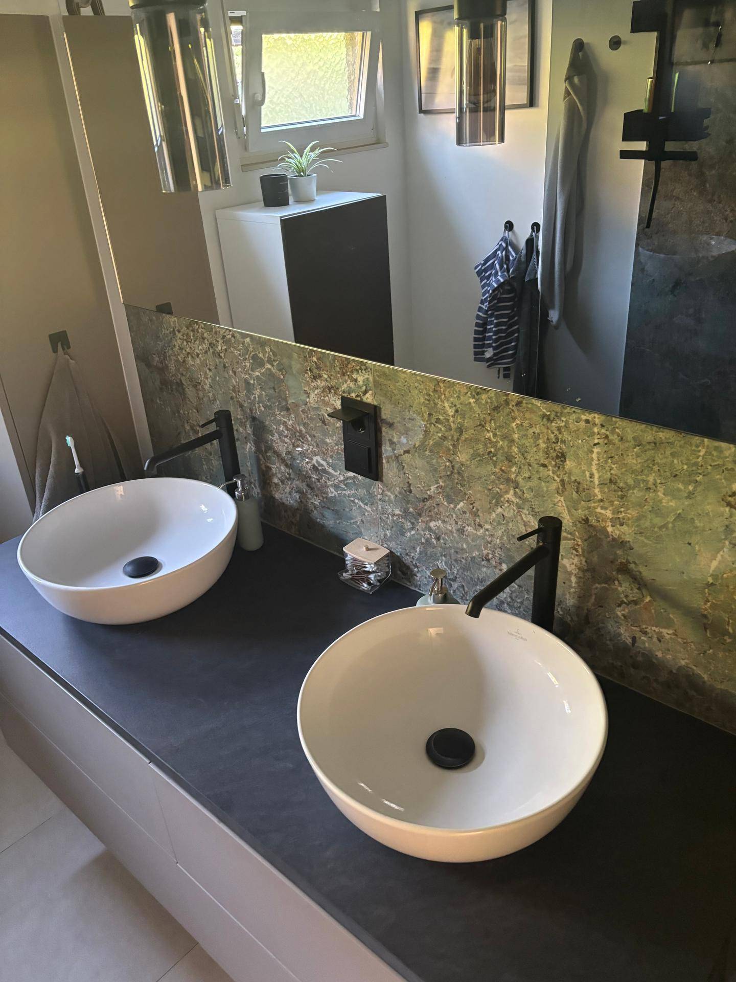 Elegantes Badezimmer mit zwei Aufsatzwaschbecken, großem Spiegel und modernen Armaturen.