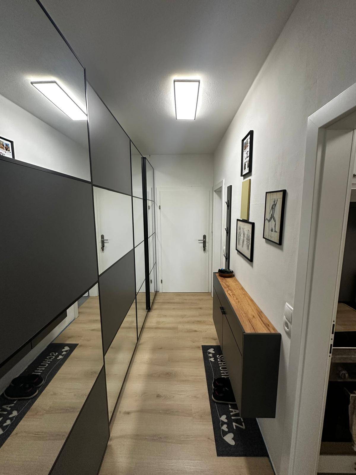 Geräumiger Flur mit integrierten Spiegelschränken und stilvoller Wanddekoration.