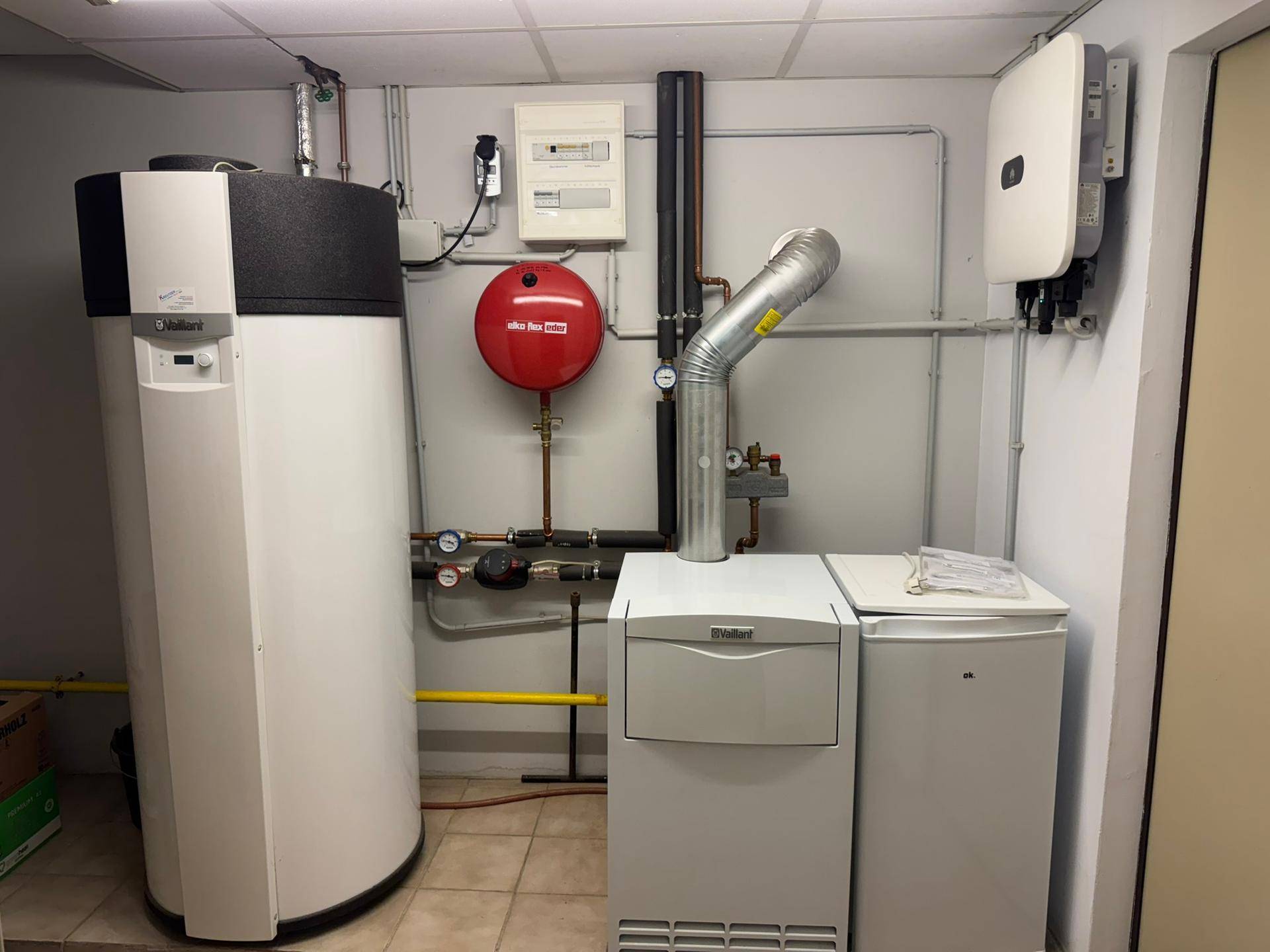 Heizraum mit moderner Wärmepumpe und Warmwasserspeicher.