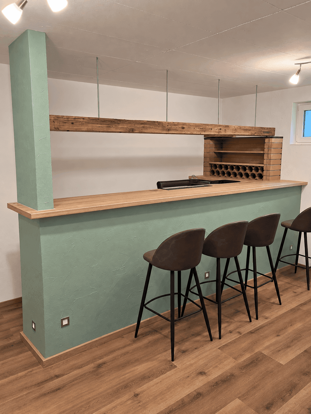 Moderne Bar im Keller mit Holztheke, Barhockern und integriertem Weinregal.