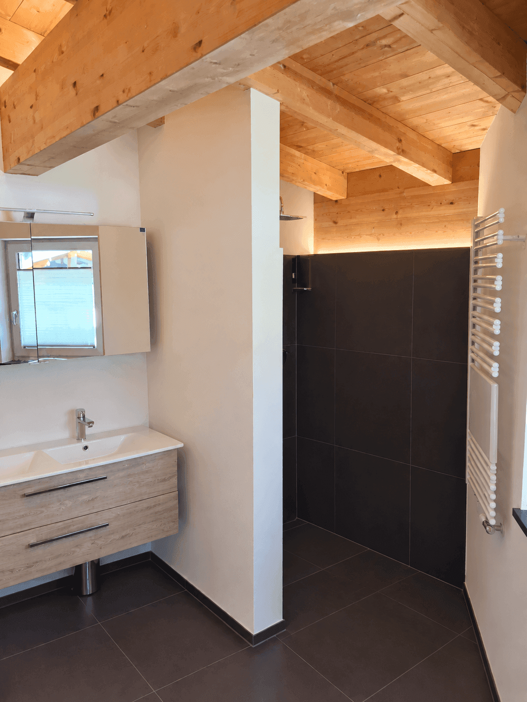 Modernes Badezimmer mit begehbarer Dusche, Einzelwaschbecken und Holzbalkendecke.