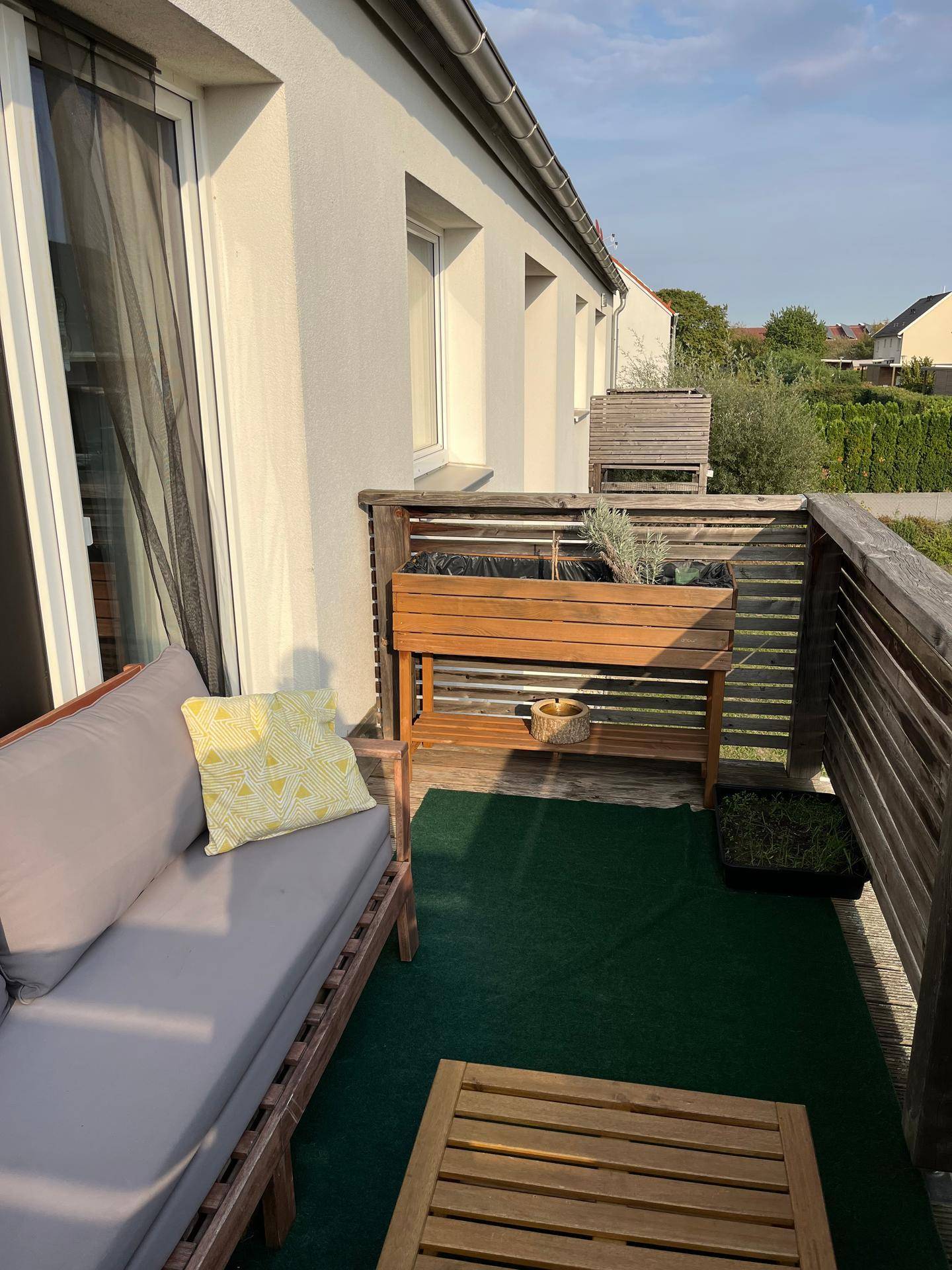 Balkon mit Holzelementen, Pflanzen und Sitzgelegenheit, bietet einen weiten Ausblick.