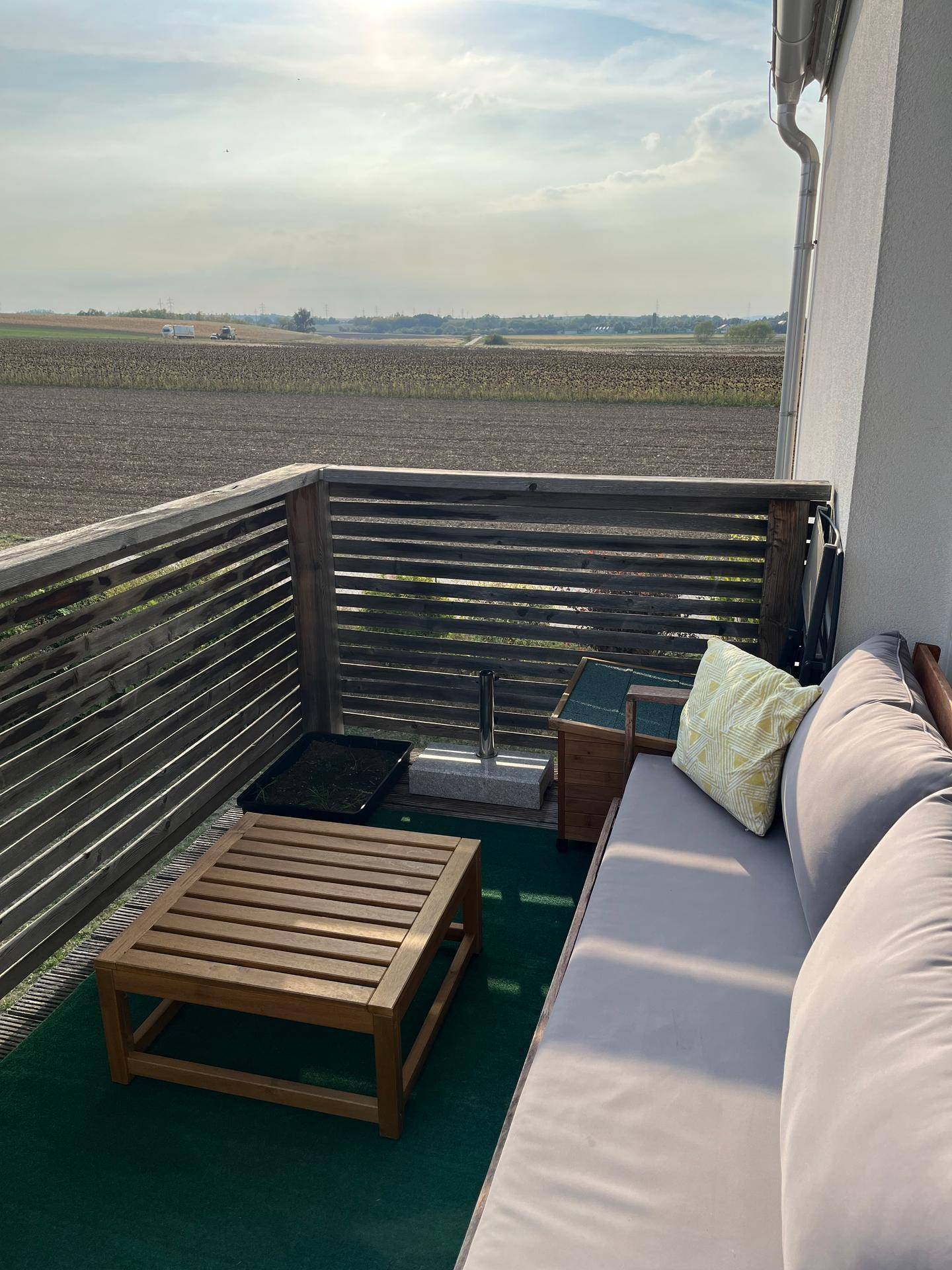 Gemütlicher Balkon mit Sitzgelegenheiten und weitem Blick über die Felder.