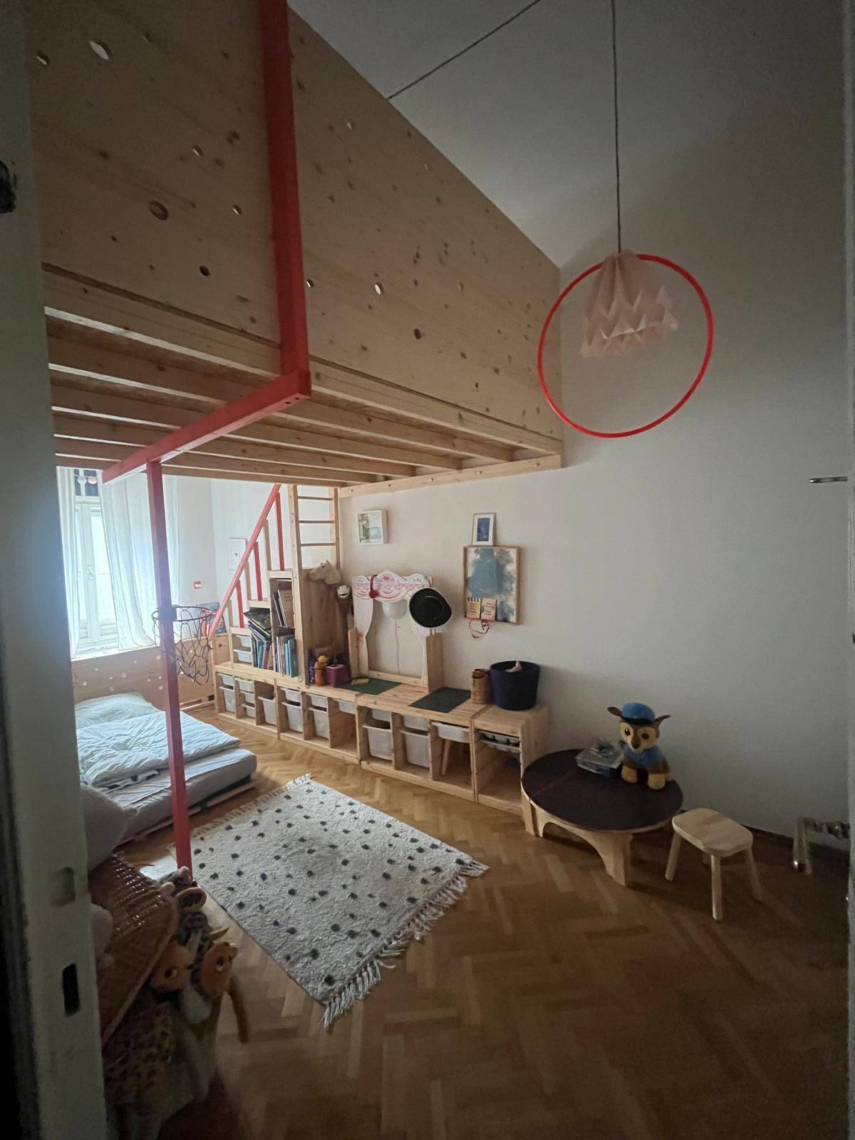 Kinderzimmer mit Hochbett, Holzboden und einem kleinen Spielbereich.