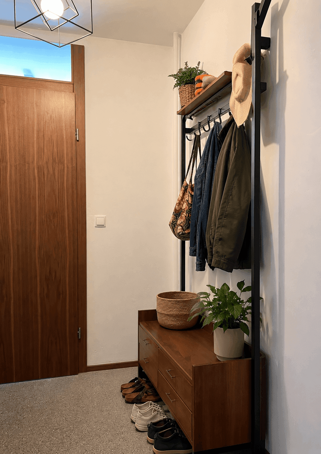 Eingangsbereich mit Garderobe, Schuhbank und Holztür, hell und funktional gestaltet.