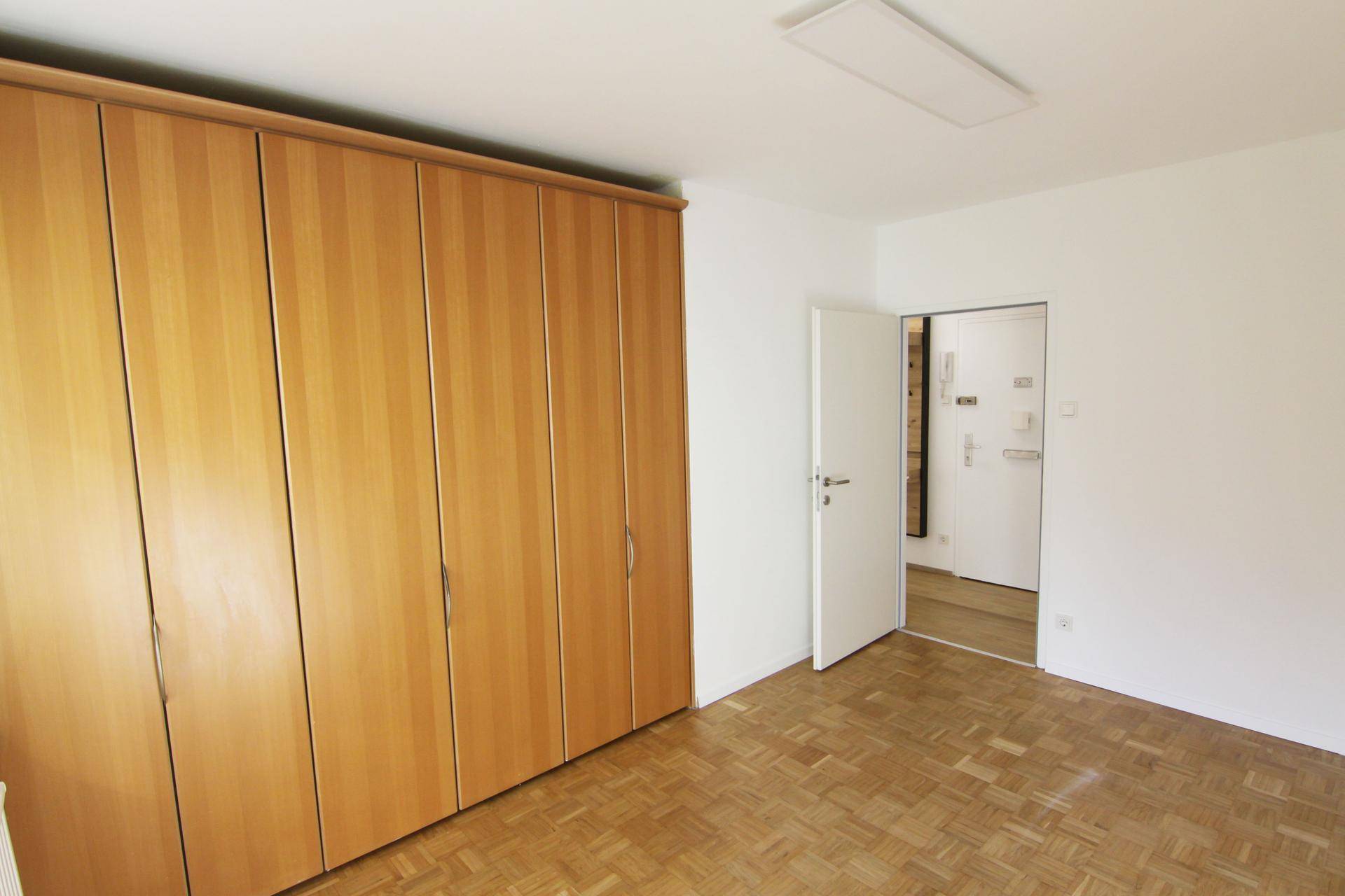 Geräumiges Schlafzimmer mit Parkettboden und großem Einbauschrank, bietet viel Stauraum.