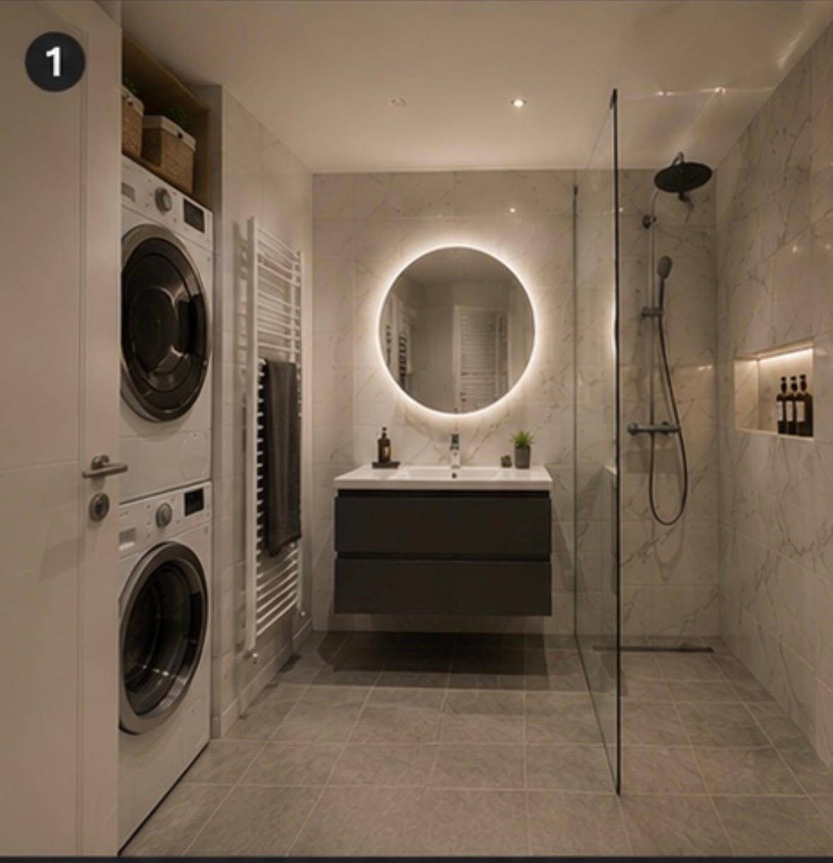 Modernes Badezimmer mit begehbarer Dusche, runden Spiegel und Waschmaschine.