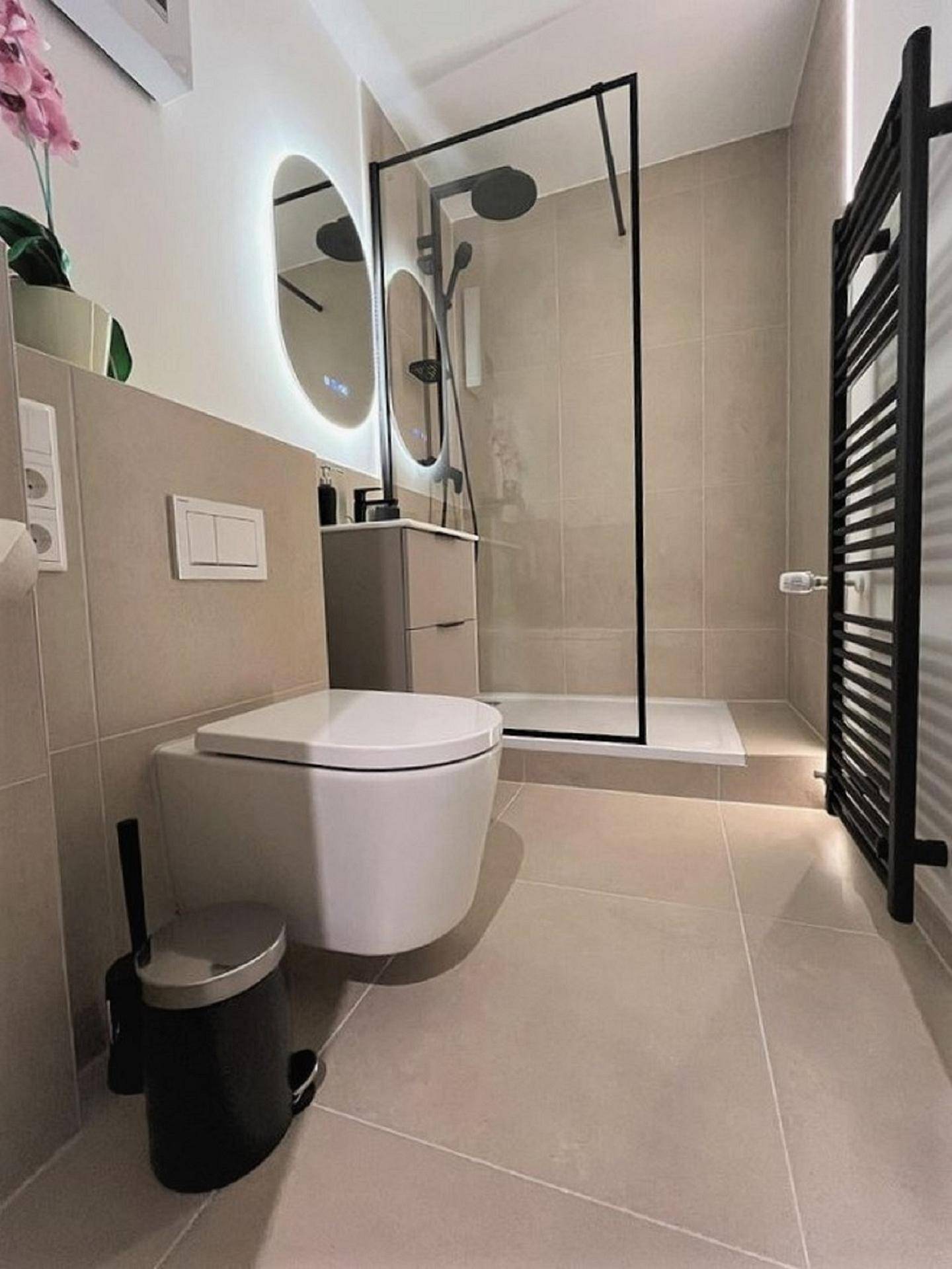Modernes Badezimmer mit begehbarer Dusche, Wand-WC und beheiztem Handtuchhalter.