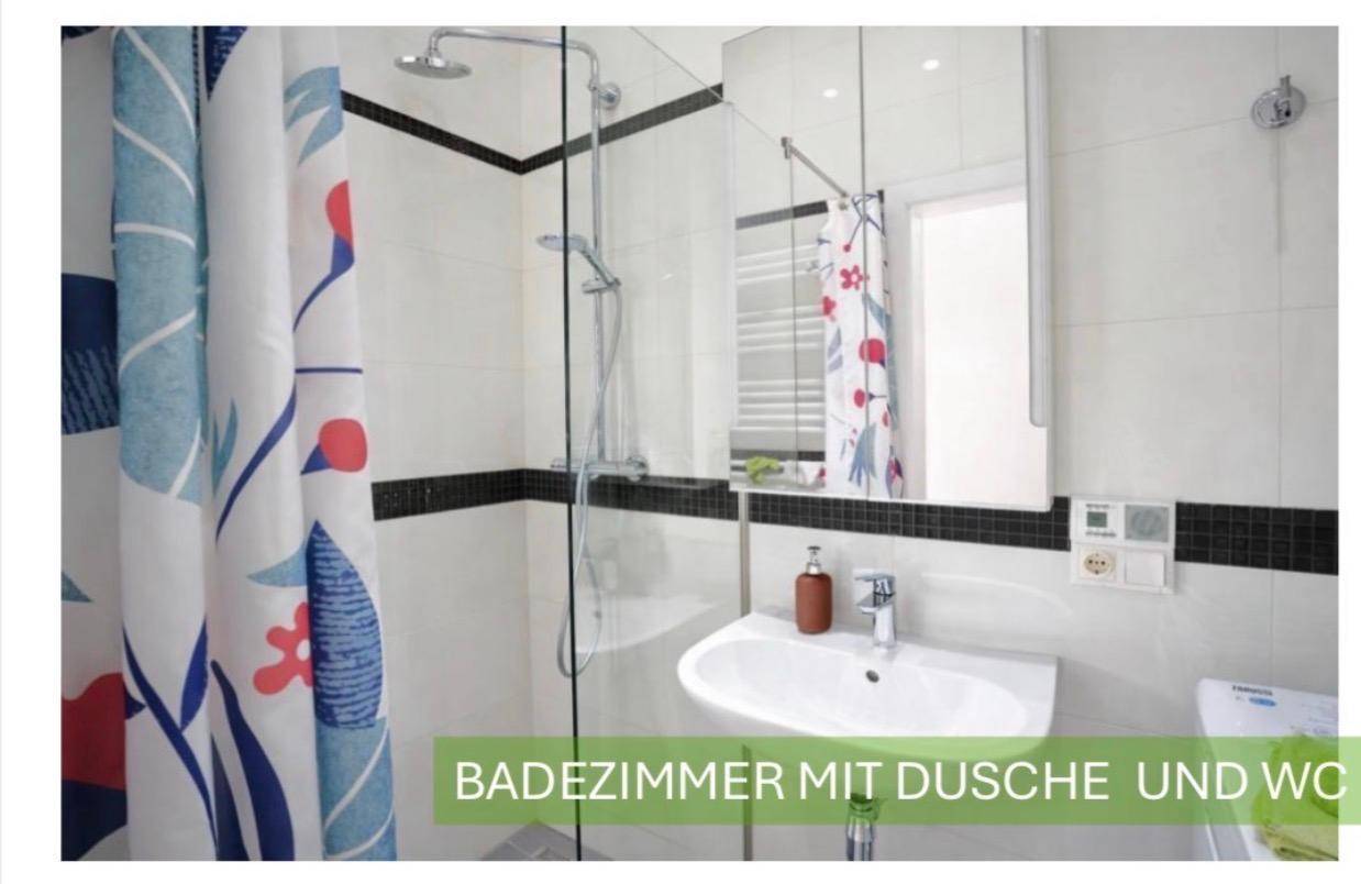 Modernes Badezimmer mit Duschkabine, Waschbecken und WC, ausgestattet mit weißen Fliesen.