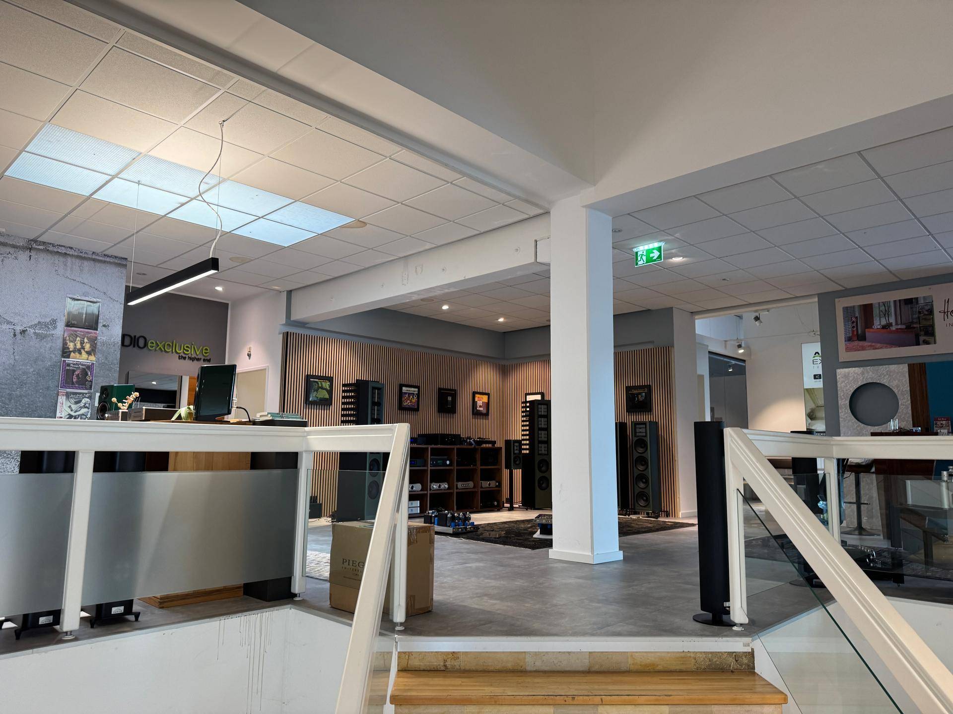 Eingerichteter Gewerberaum mit moderner Deckenbeleuchtung und Holzvertäfelung, ideal als Ausstellungsfläche.