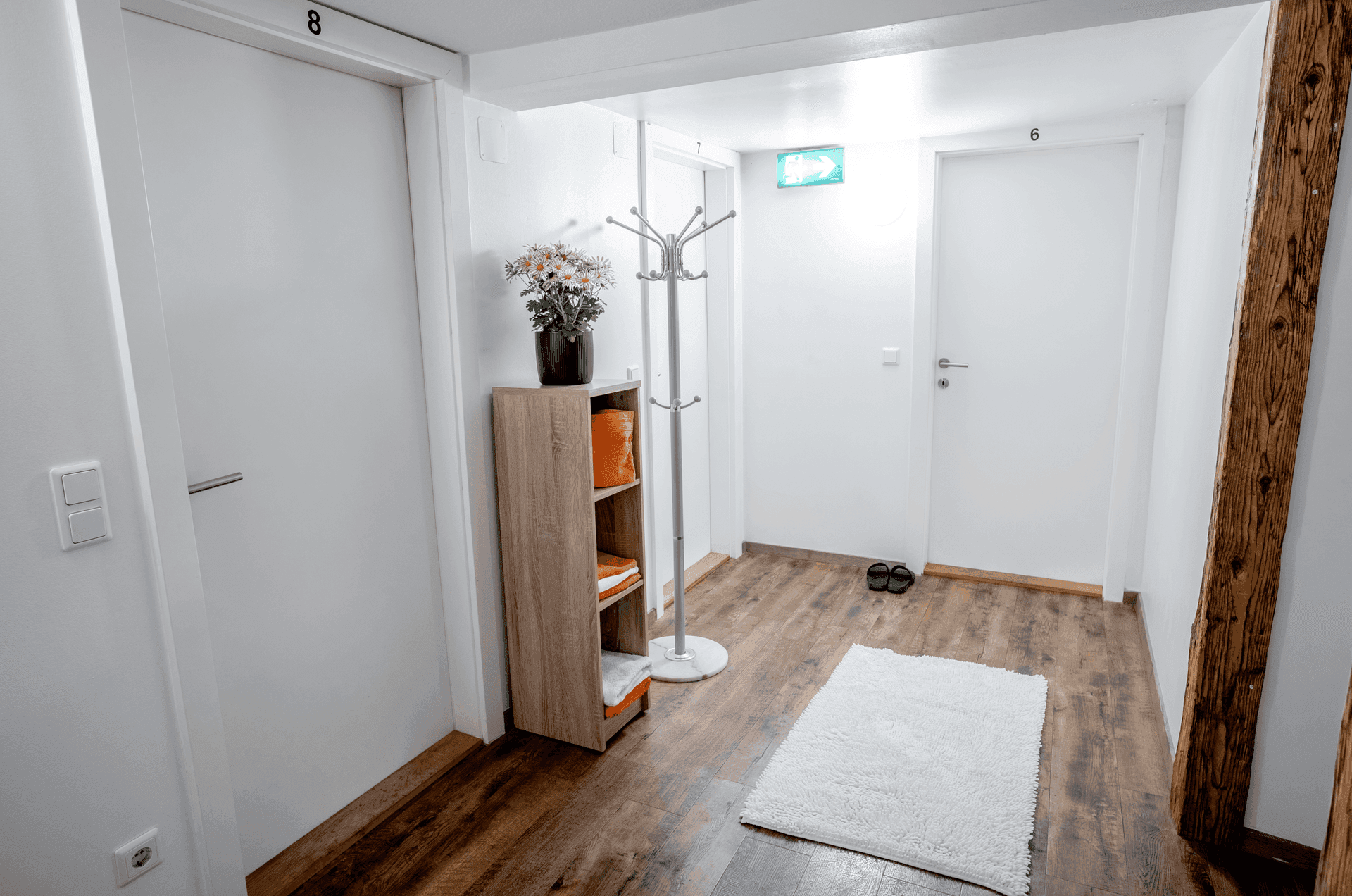 Heller Flur mit mehreren Türen, Garderobe und Holzbalken, einladend gestaltet.