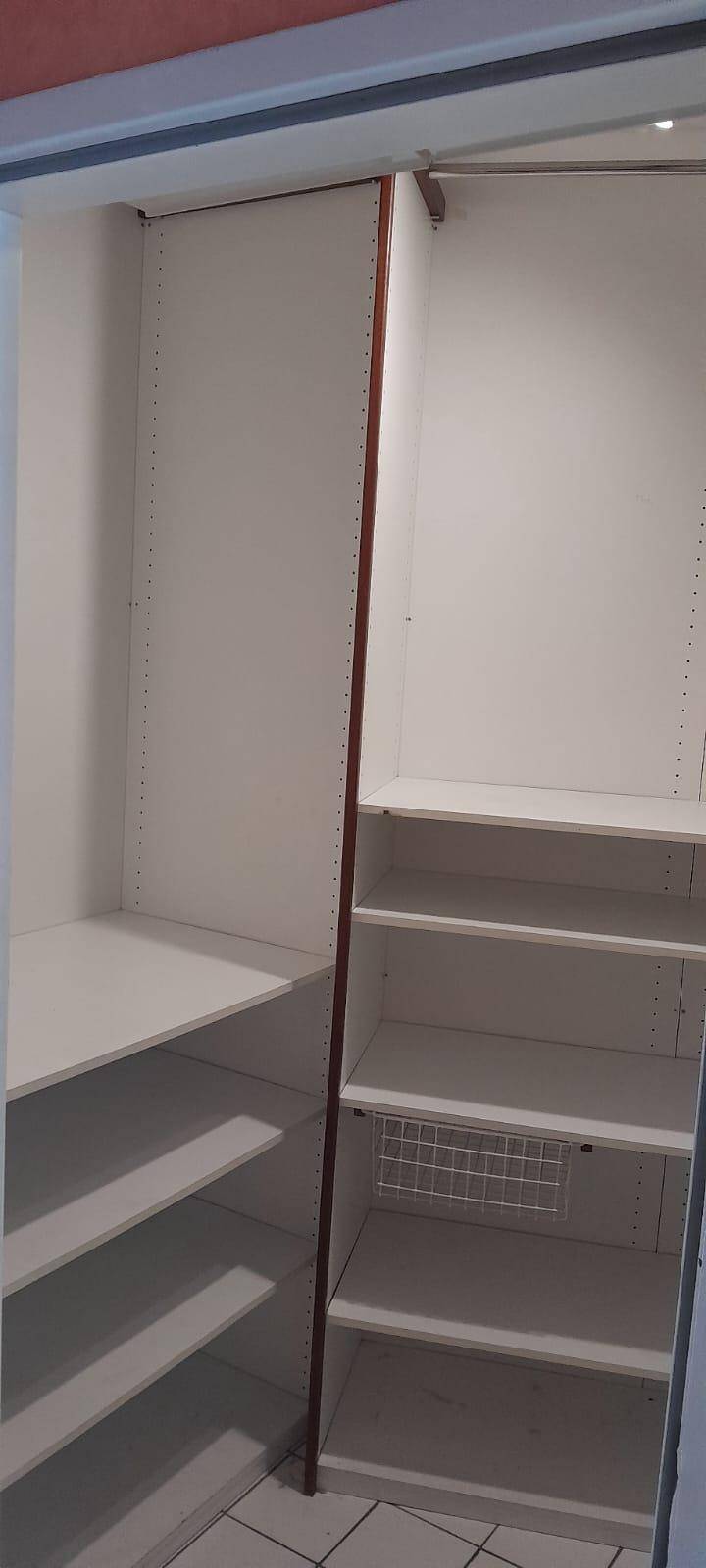 Begehbarer Kleiderschrank mit praktischen Regalsystemen und viel Stauraum.