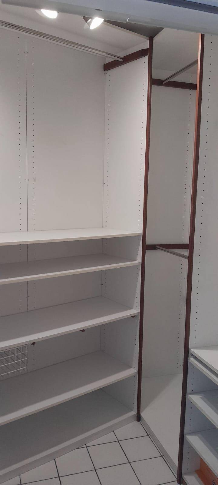 Geräumiger begehbarer Kleiderschrank mit vielen Regalen und Aufhängemöglichkeiten.