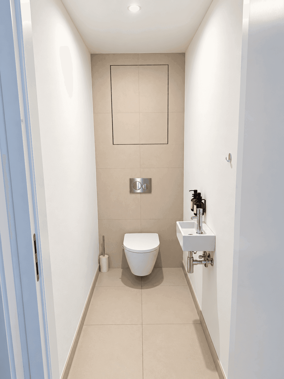 Kleines, modernes Gäste-WC mit wandhängender Toilette und minimalistischem Waschbecken.