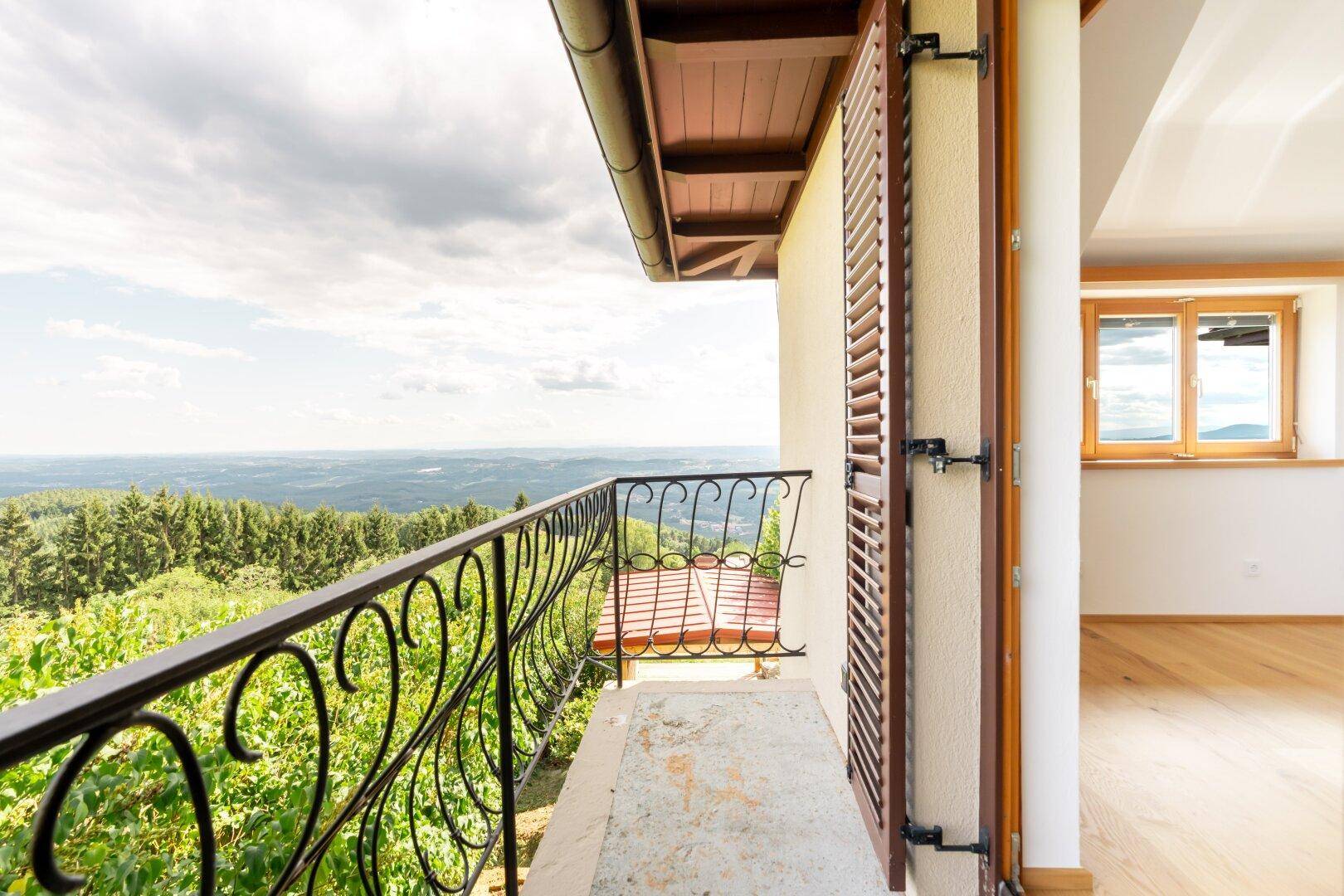 Kleiner Balkon mit schmiedeeisernem Geländer und atemberaubendem Panoramablick über die Landschaft.