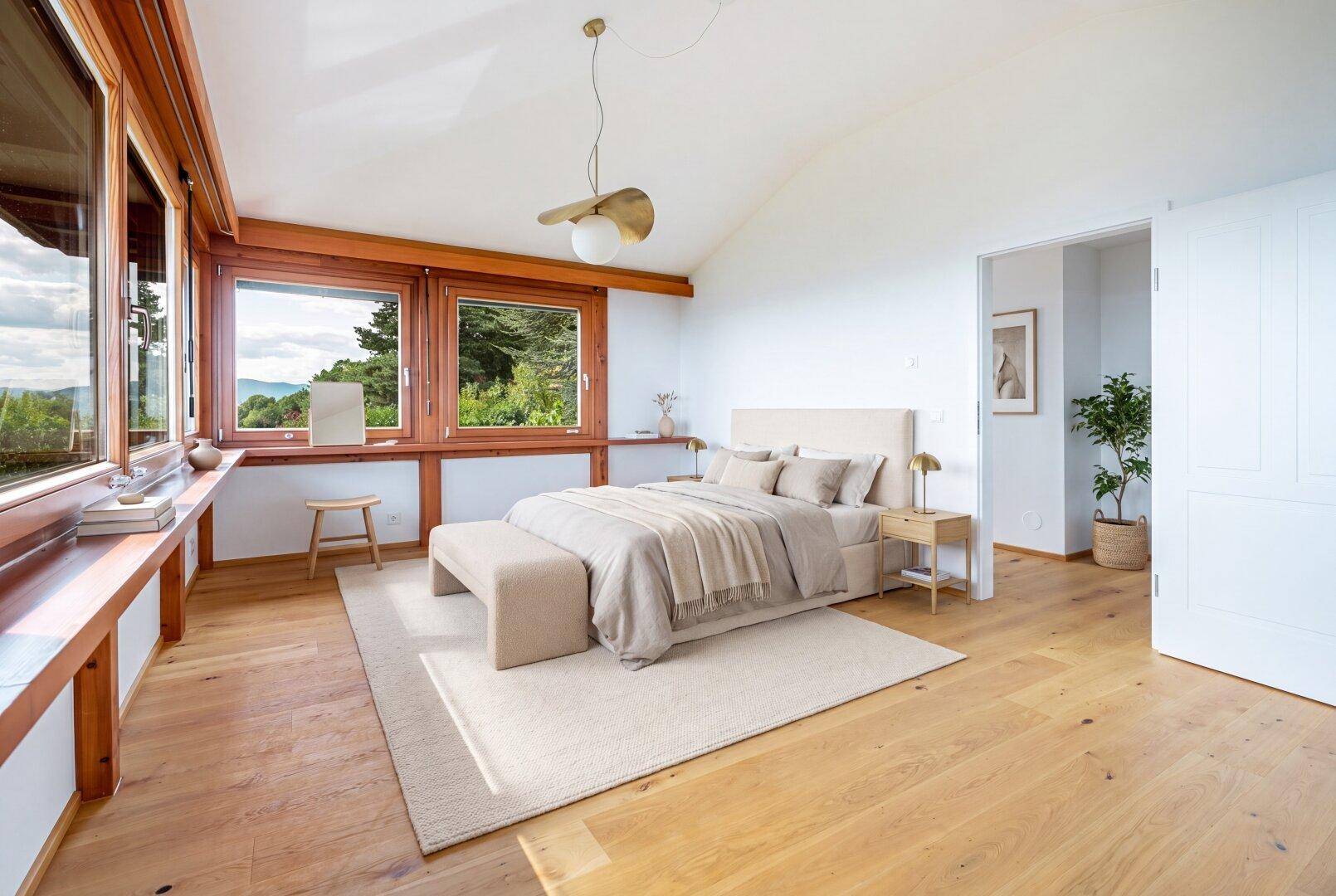 Gemütliches Schlafzimmer mit Holzboden, großen Fenstern und einem bequemen Doppelbett mit Blick ins Grüne.
