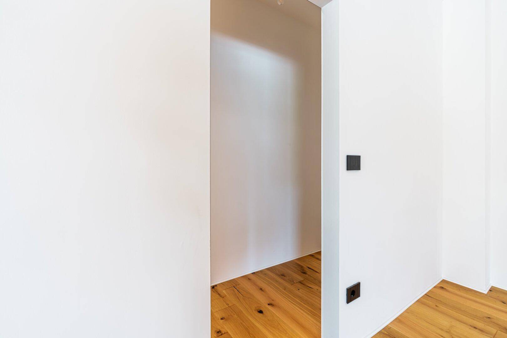 Kleiner, heller Abstellraum mit Holzboden, ideal für zusätzlichen Stauraum.