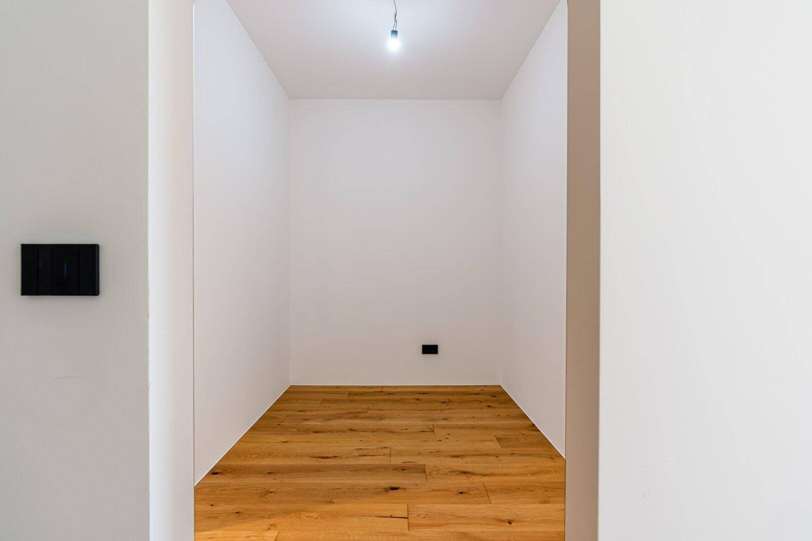 Kleiner, heller Abstellraum mit Holzboden, ideal für zusätzlichen Stauraum.