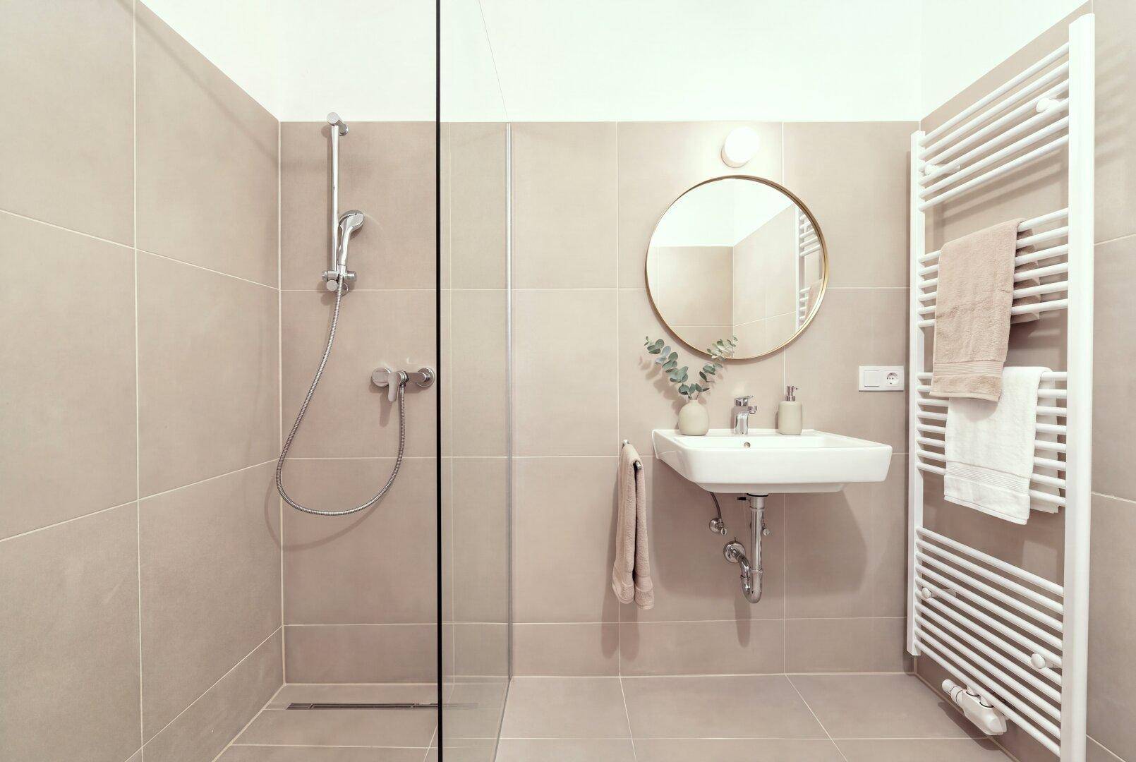 Modernes Badezimmer mit ebenerdiger Dusche, Einzelwaschbecken und beheiztem Handtuchhalter.