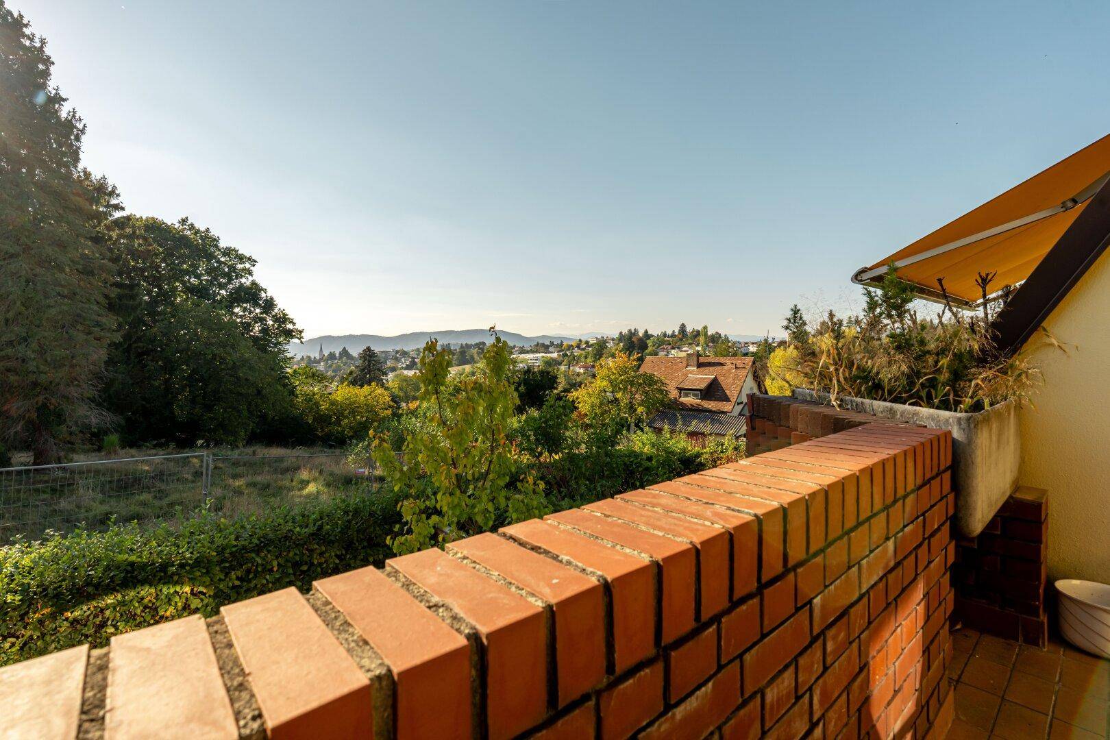 Weitläufiger Ausblick von der Terrasse über die umliegende Landschaft und Häuser.