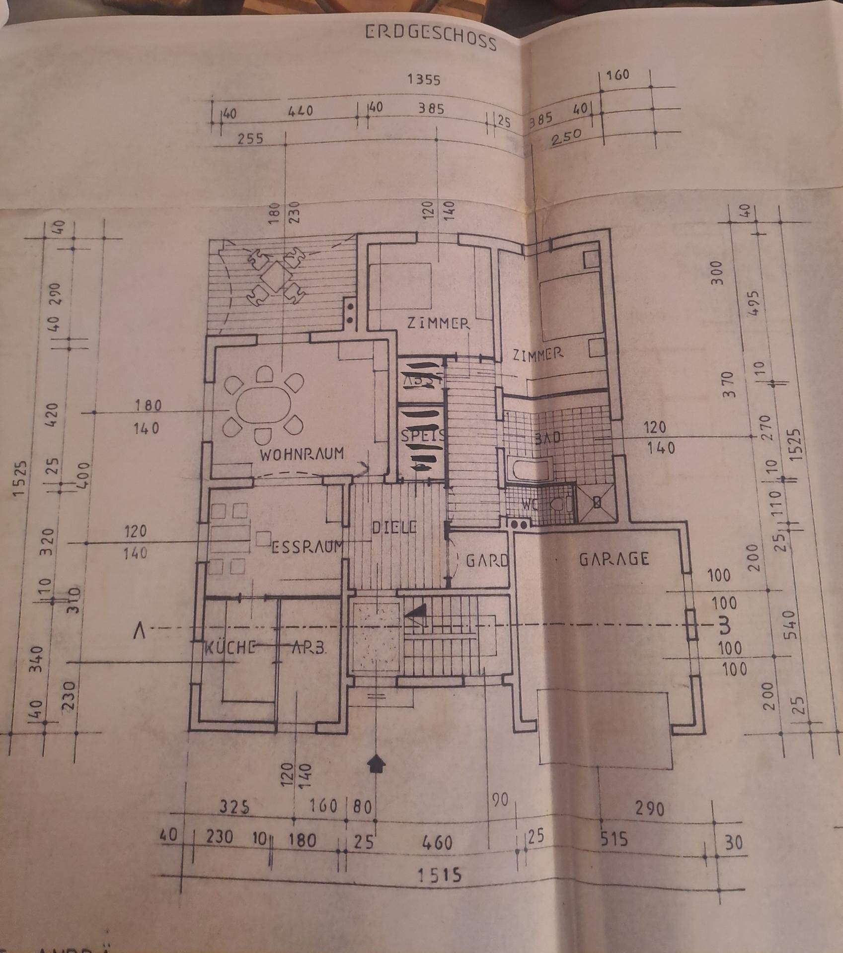 Grundriss des Erdgeschosses mit Wohnzimmer, Esszimmer, Küche und Garage.