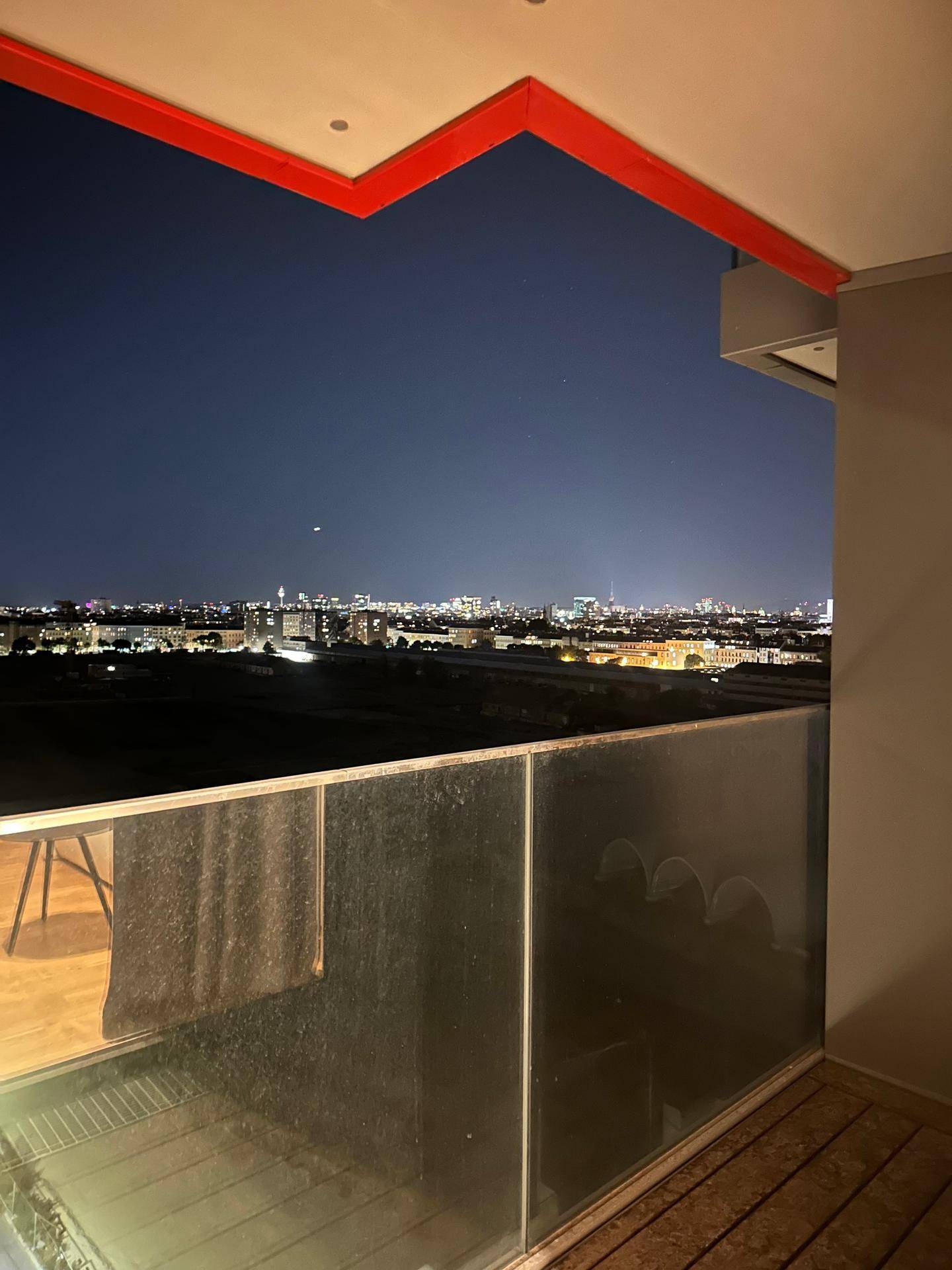 Balkon bei Nacht mit weitem Blick über die Stadtlichter und die nächtliche Umgebung.