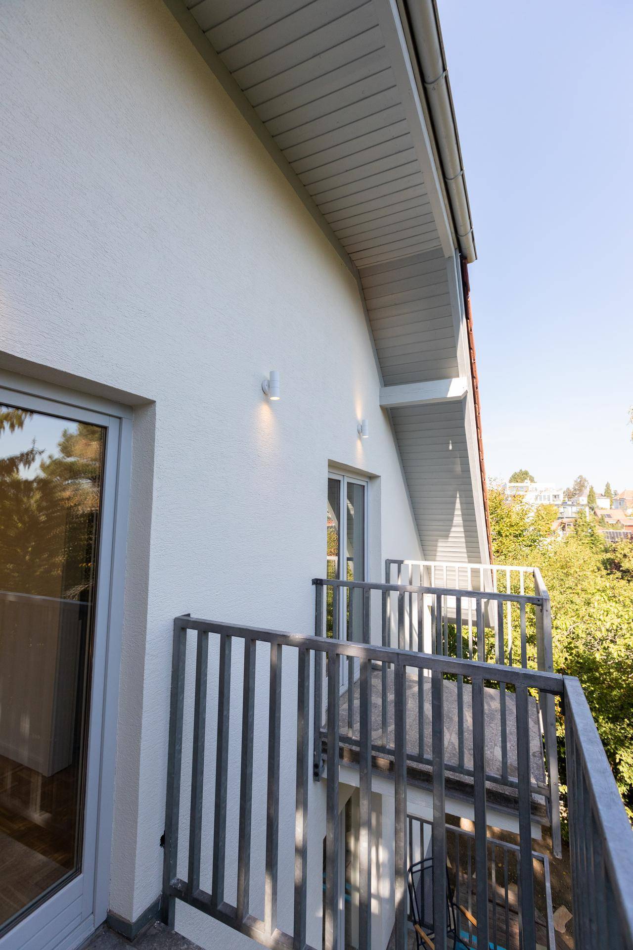 Heller Balkon mit Metallgeländer, der einen schönen Blick auf die umliegende Natur bietet.