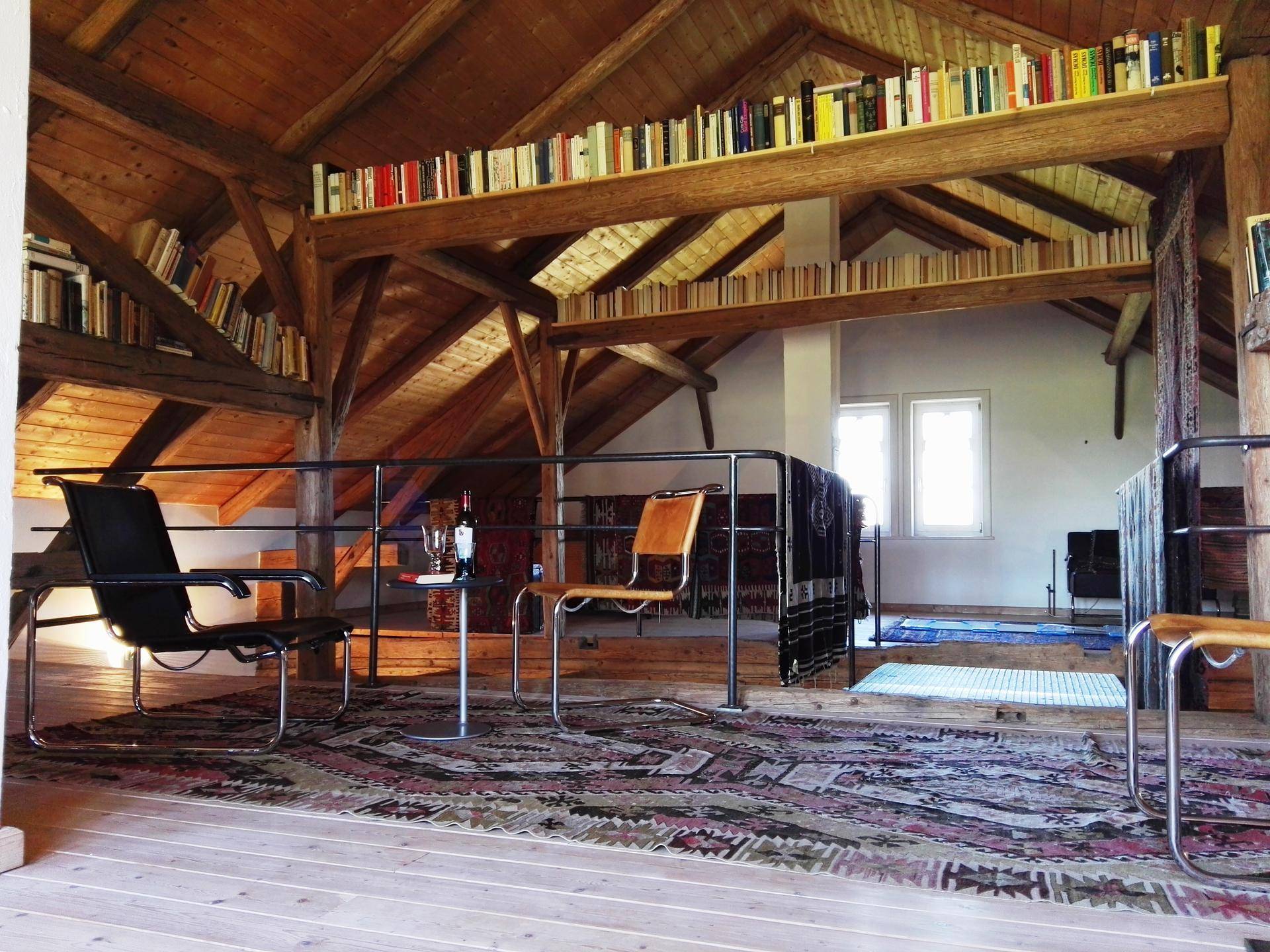 Geräumige Galerie im Dachgeschoss mit Sitzgelegenheiten, Teppich und Bücherregalen.