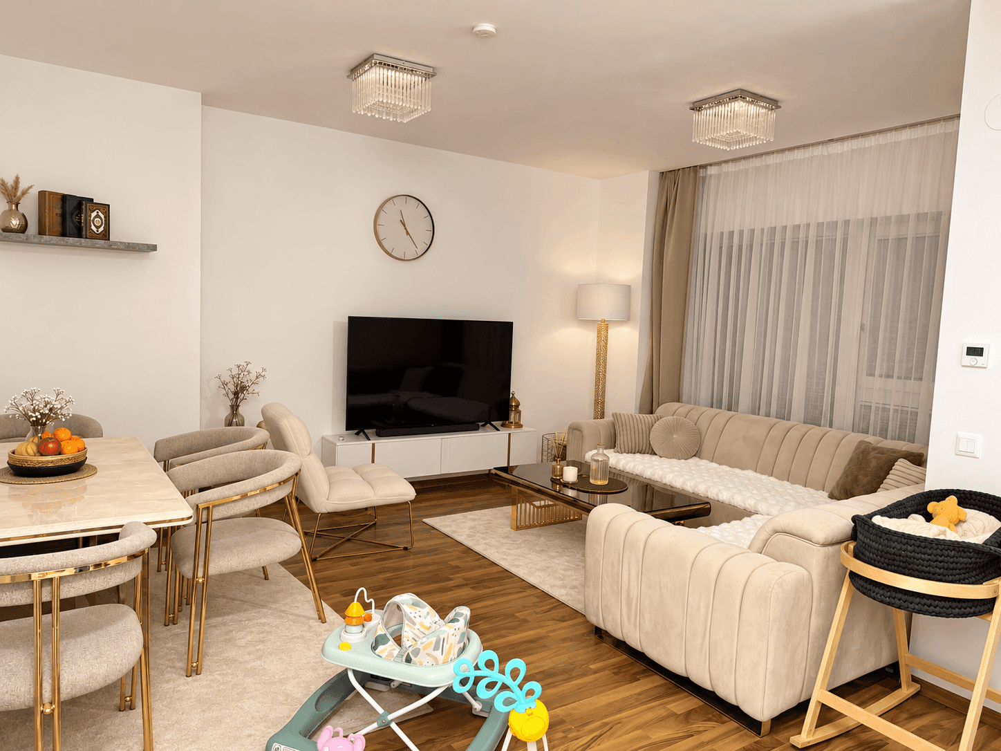 Geräumiger offener Wohn- und Essbereich mit beigem Sofa, Esstisch und Holzboden.
