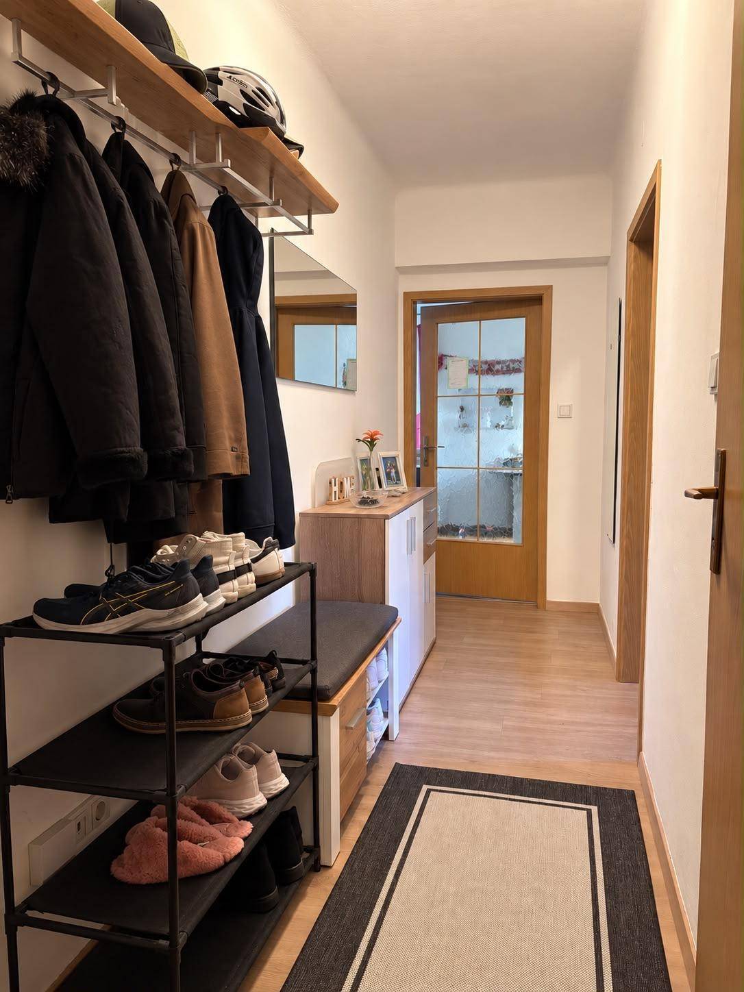 Freundlicher Flur mit Garderobe, Schuhablage und Zugang zu weiteren Räumen.