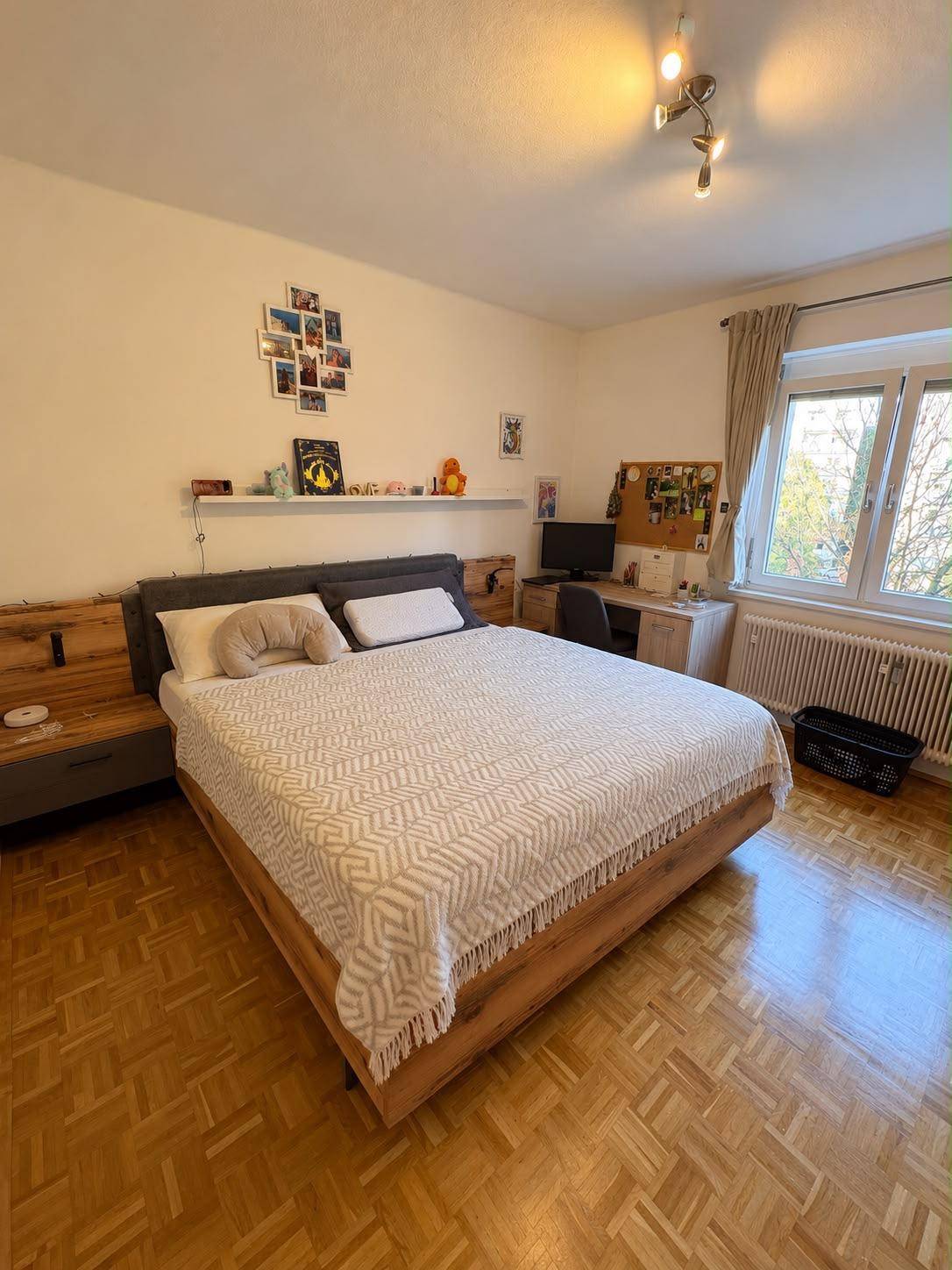 Gemütliches Schlafzimmer mit Doppelbett, Schreibtisch und Parkettboden.